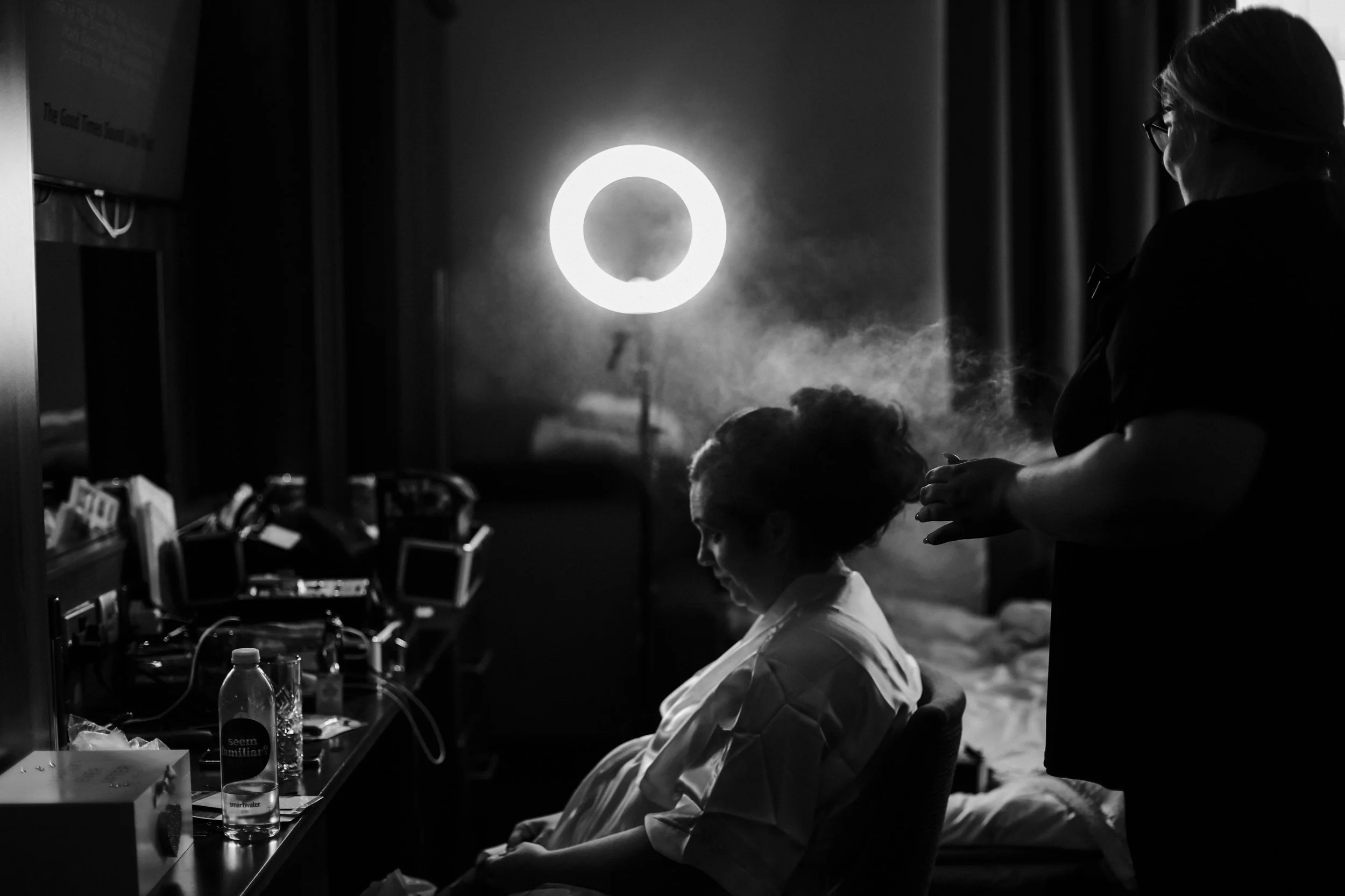 bride getting her hair done with hair spray the morning of her wedding  Formby Hall Sefton Wedding Photography
