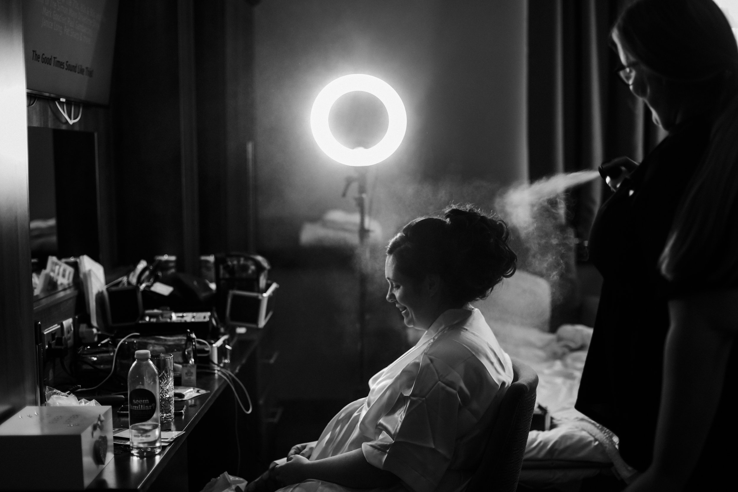  bride getting her hair done with hair spray the morning of her wedding Formby Hall Sefton Wedding Photography