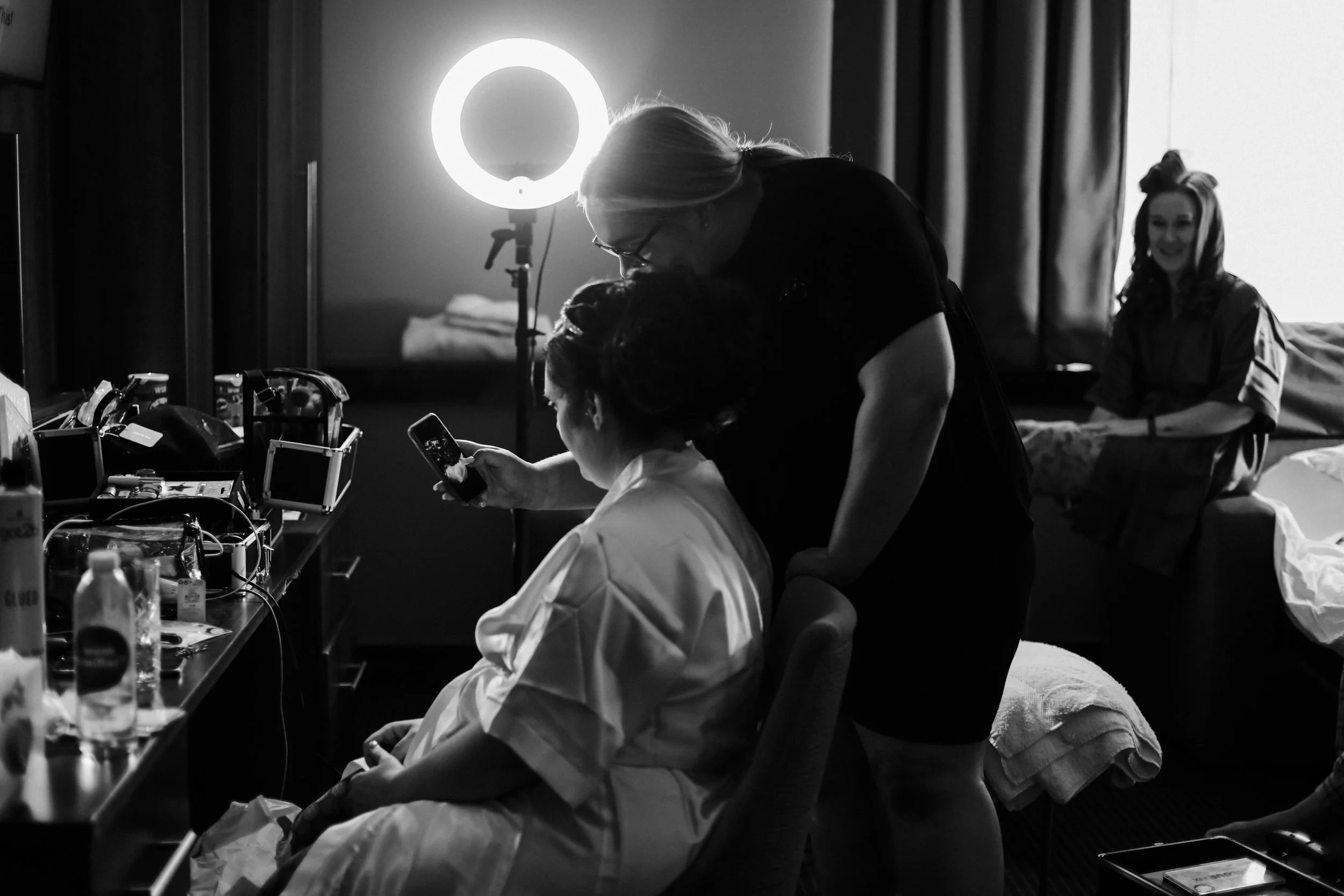 bride and makeup artist discussing ideas and showing examples on her mobile phone Formby Hall Sefton Wedding Photography
