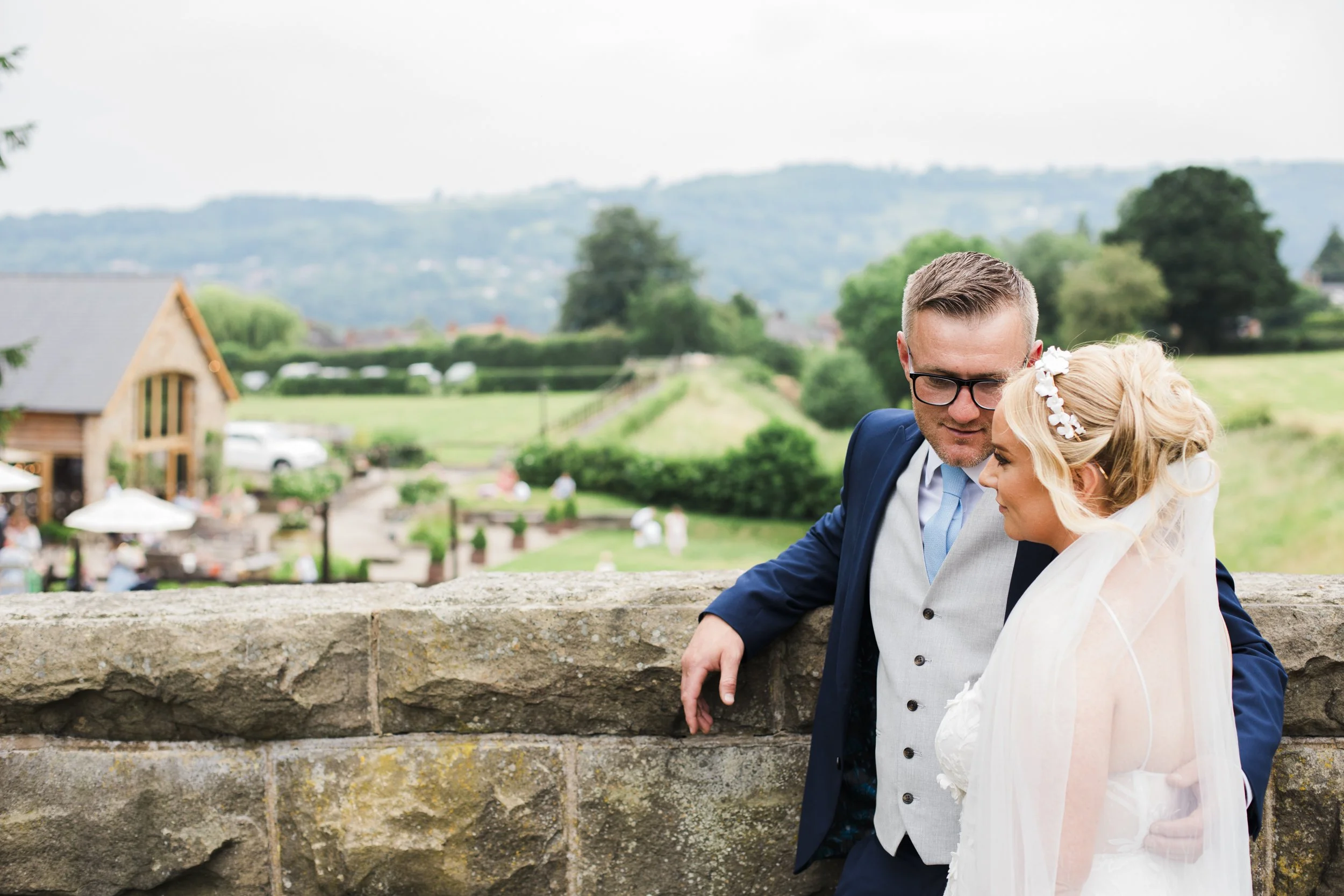Groom caught lovingly glancing at bride on Tower Hill Barns Railway Bridge