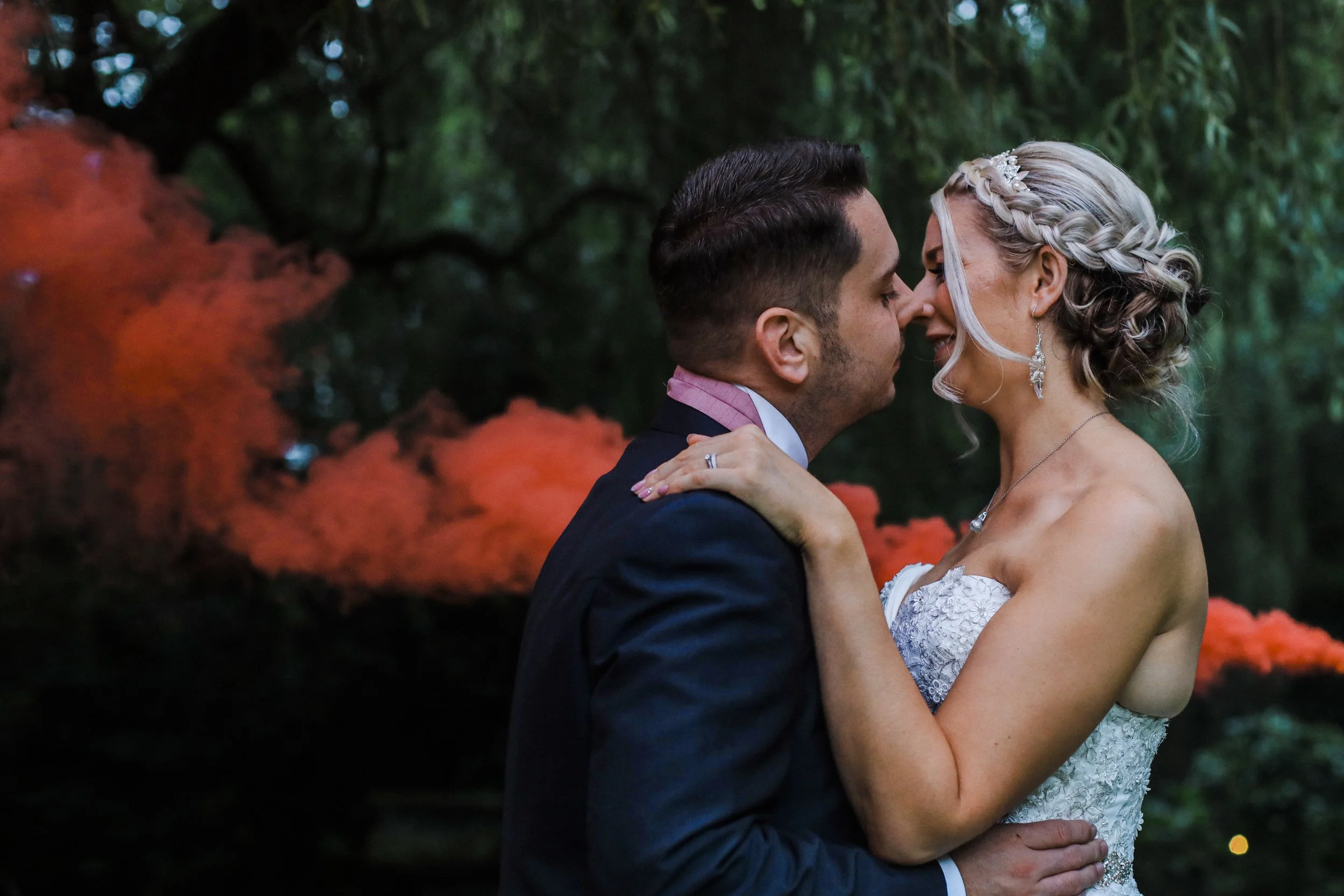 Bride and Groom Share a Romantic Kiss with a Dramatic Red Smoke Effect on the Grounds of Brook Hall Hotel Liverpool Wedding Photography 