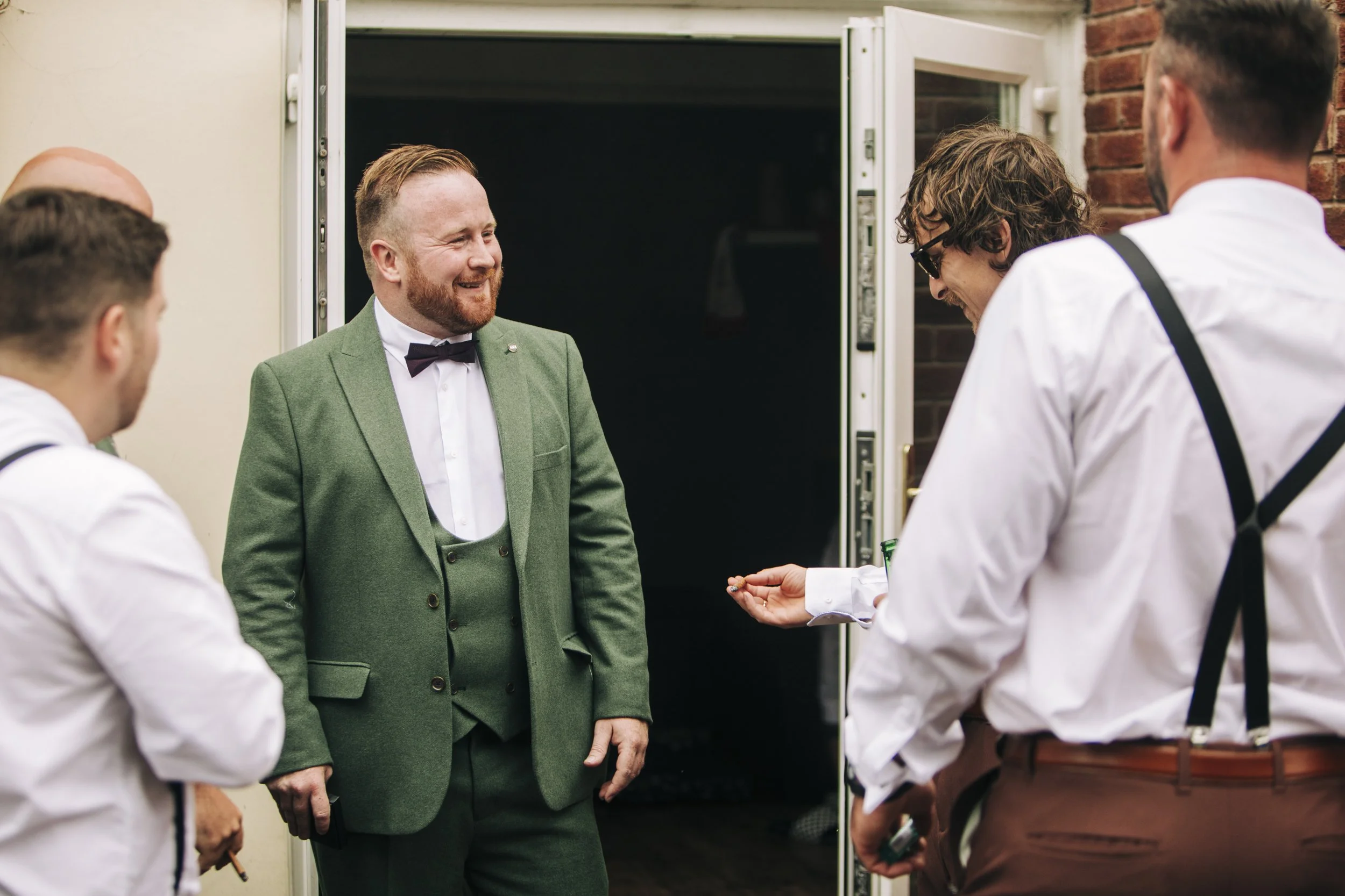 On the wedding morning, the groom radiates joy, sharing laughs and camaraderie with groomsmen. Genuine smiles set the tone for a day filled with celebration and cherished memories