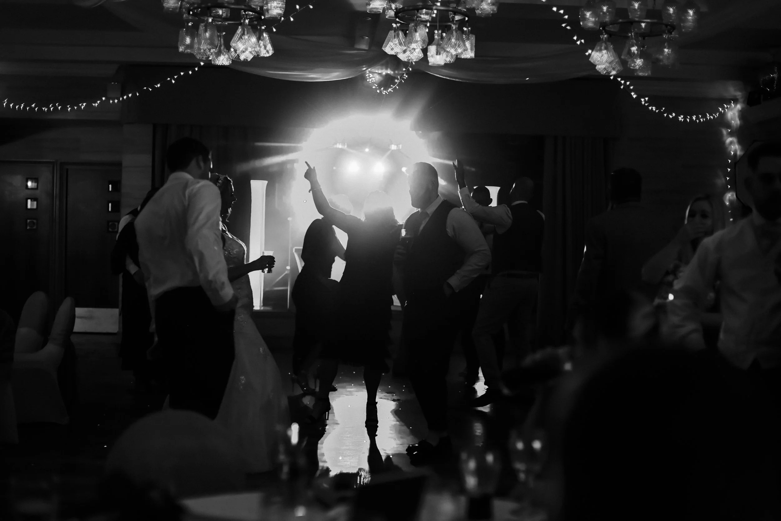bride and groom enjoying their party with dj lights illuminating them and their guests on the dance floor at the brook hall hotel Liverpool Wedding Photographer.   