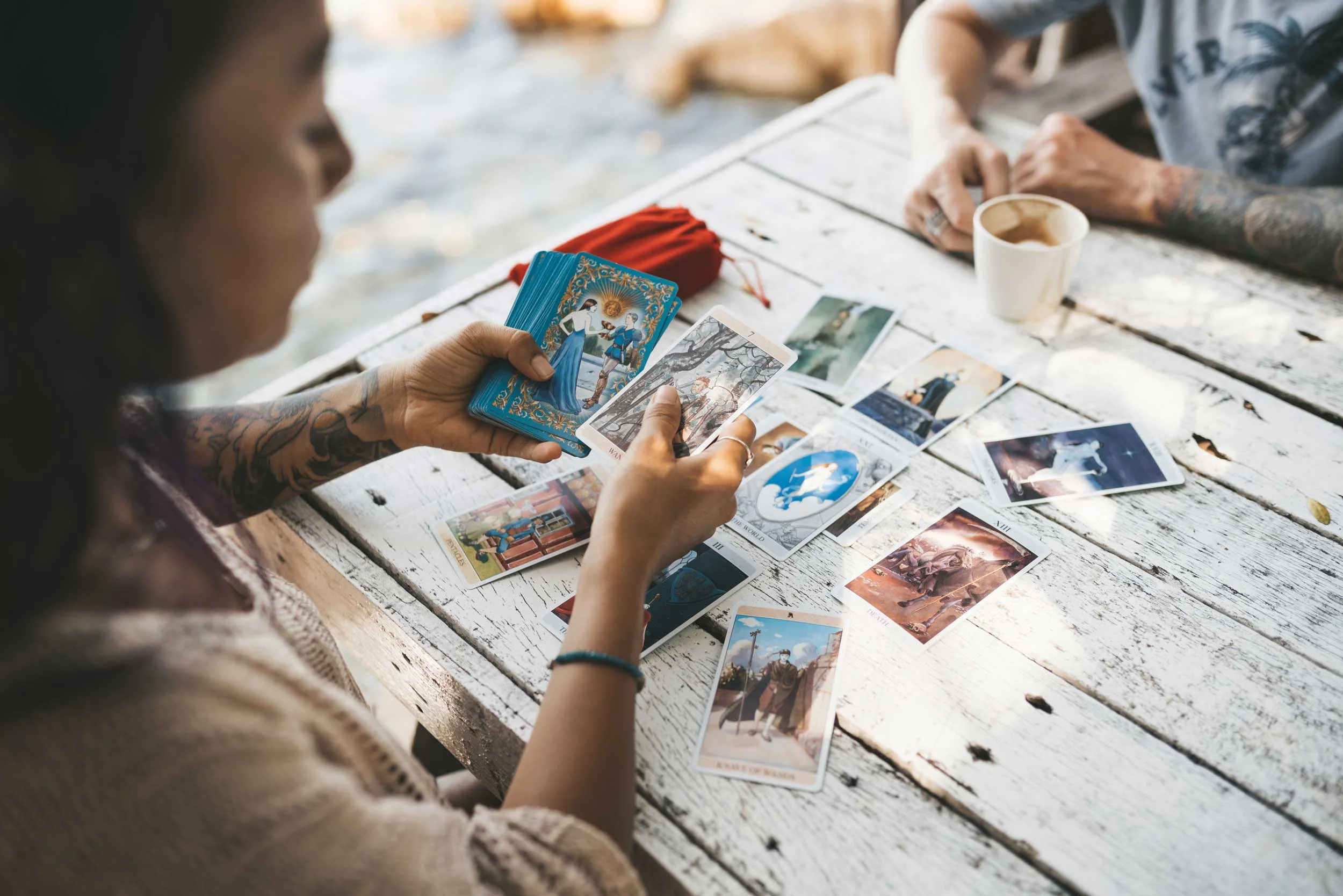 A young woman reading tarot for a client.