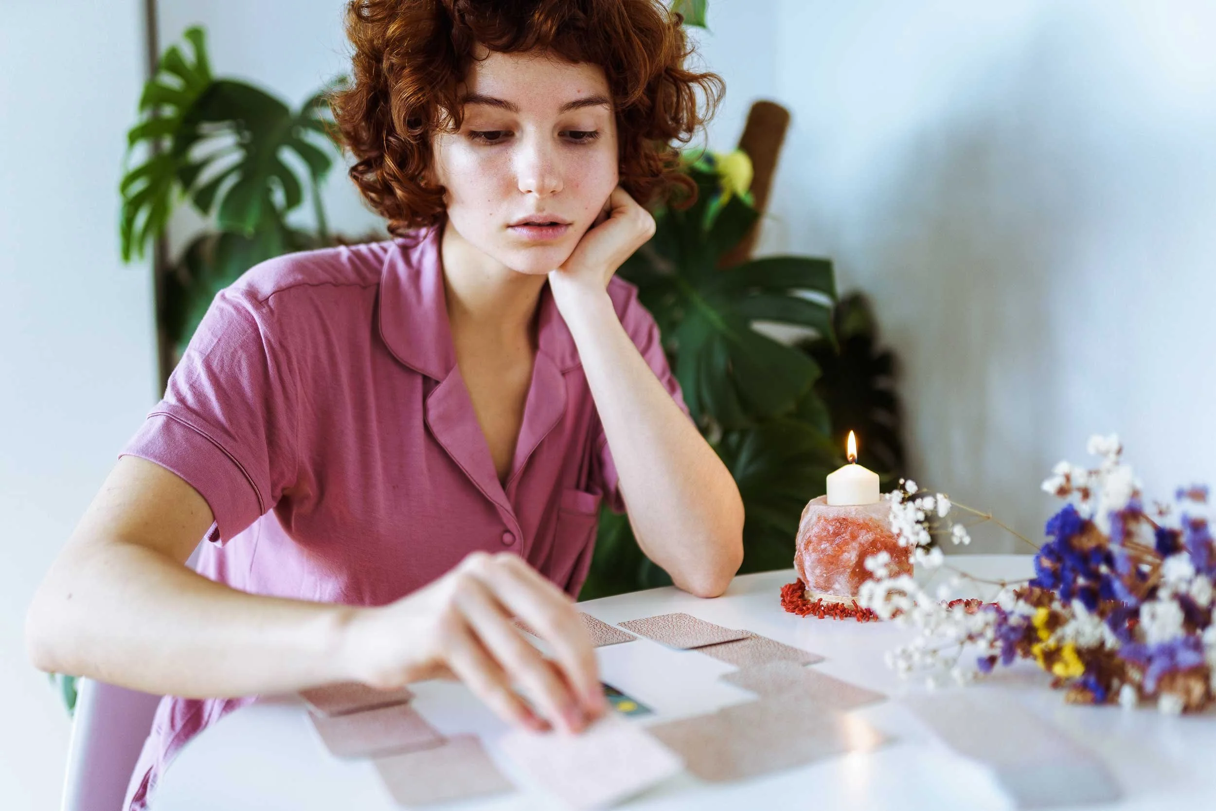 A young woman contemplates the cards.