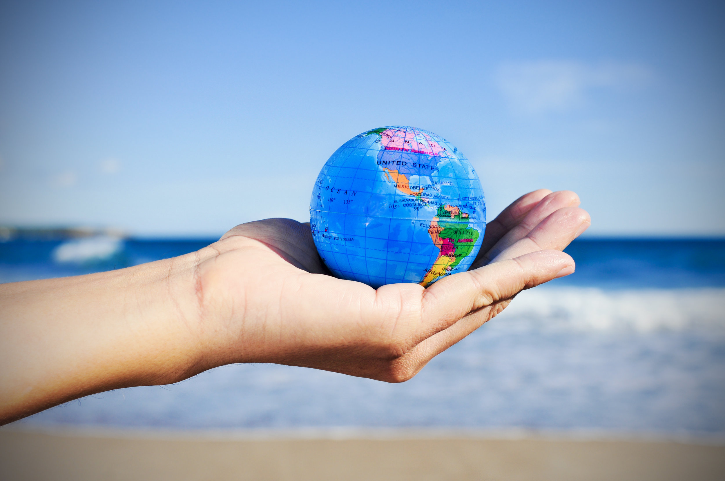 young man with a world globe in his hand, vignetted