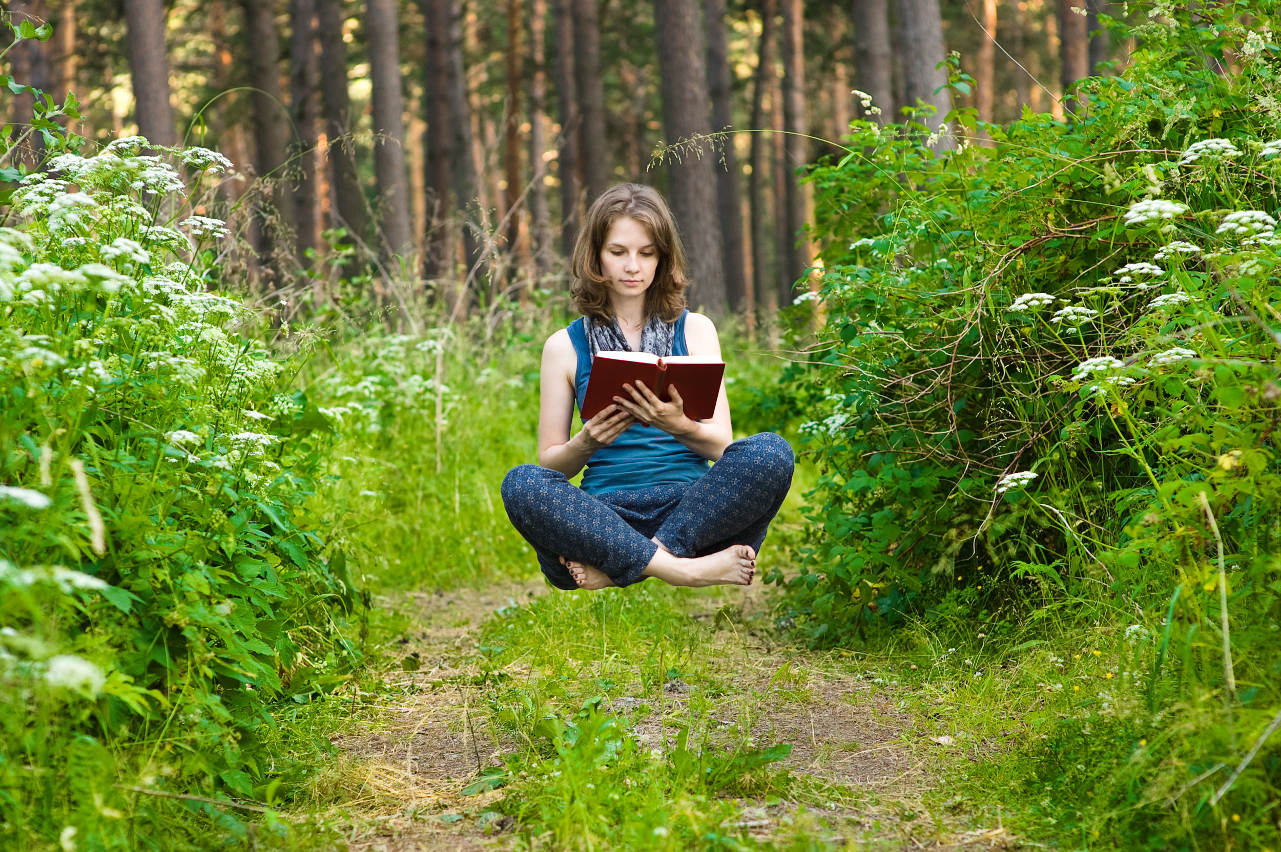 Young woman levitating with the book