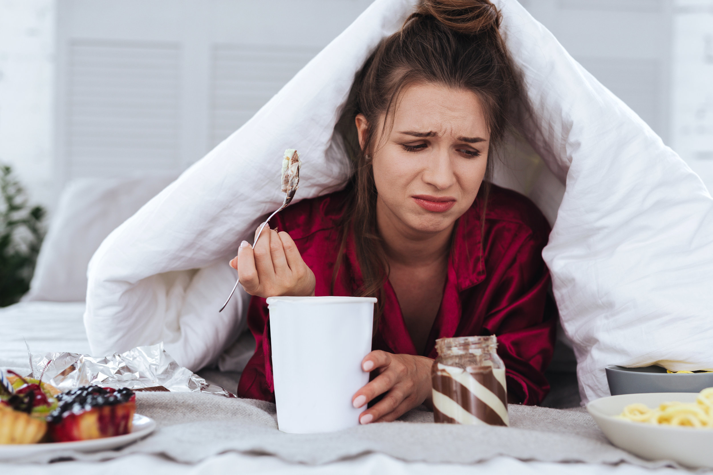 Ice cream. Stressed emotional woman eating big ice cream and crying after breakup with her handsome boyfriend