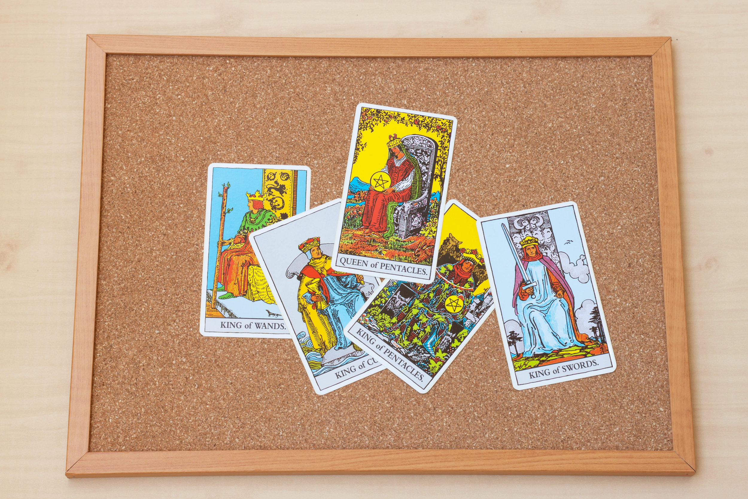 Tarot court cards on the cork board. Queen and King cards.