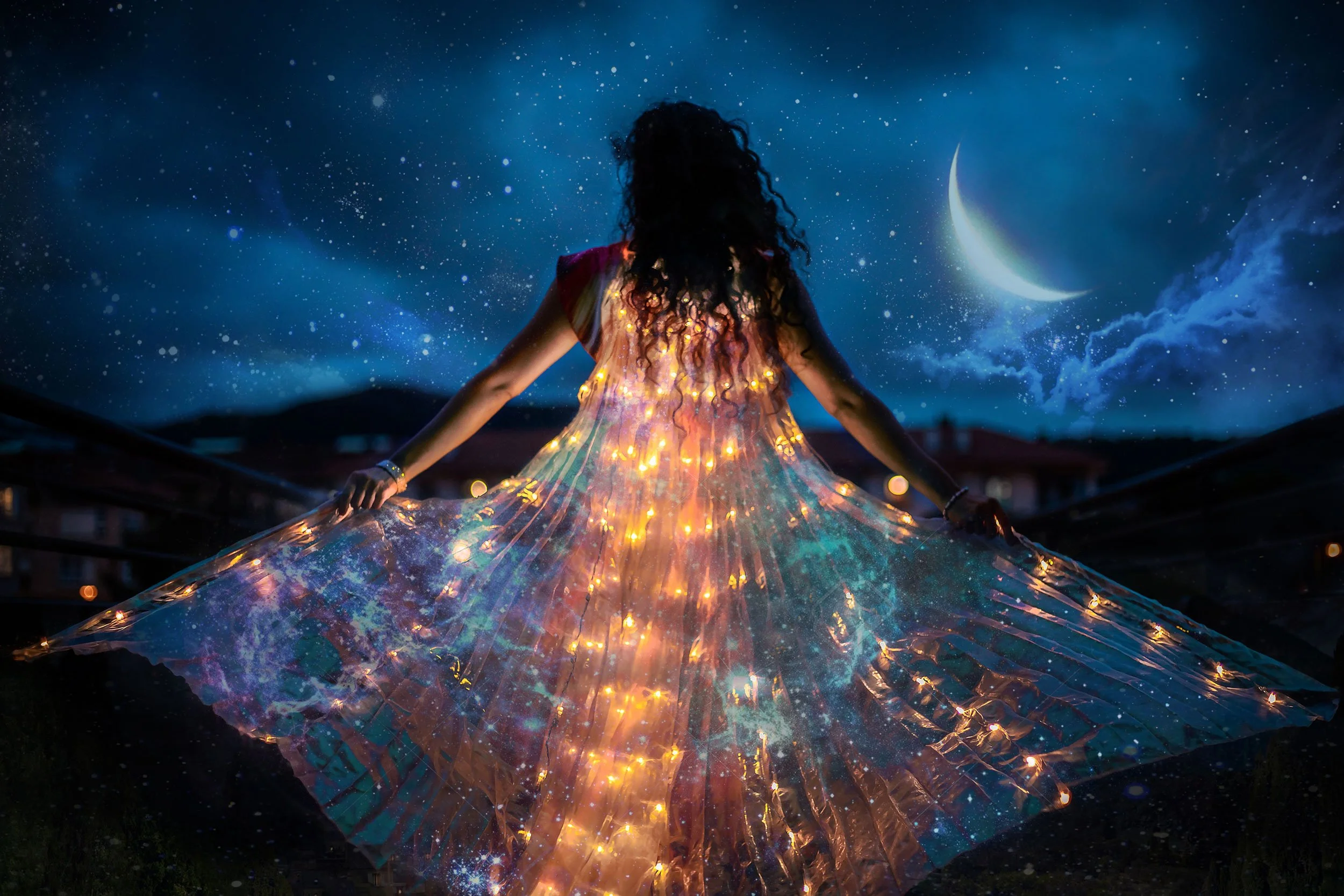 Woman in a glowing dress looking at the moon