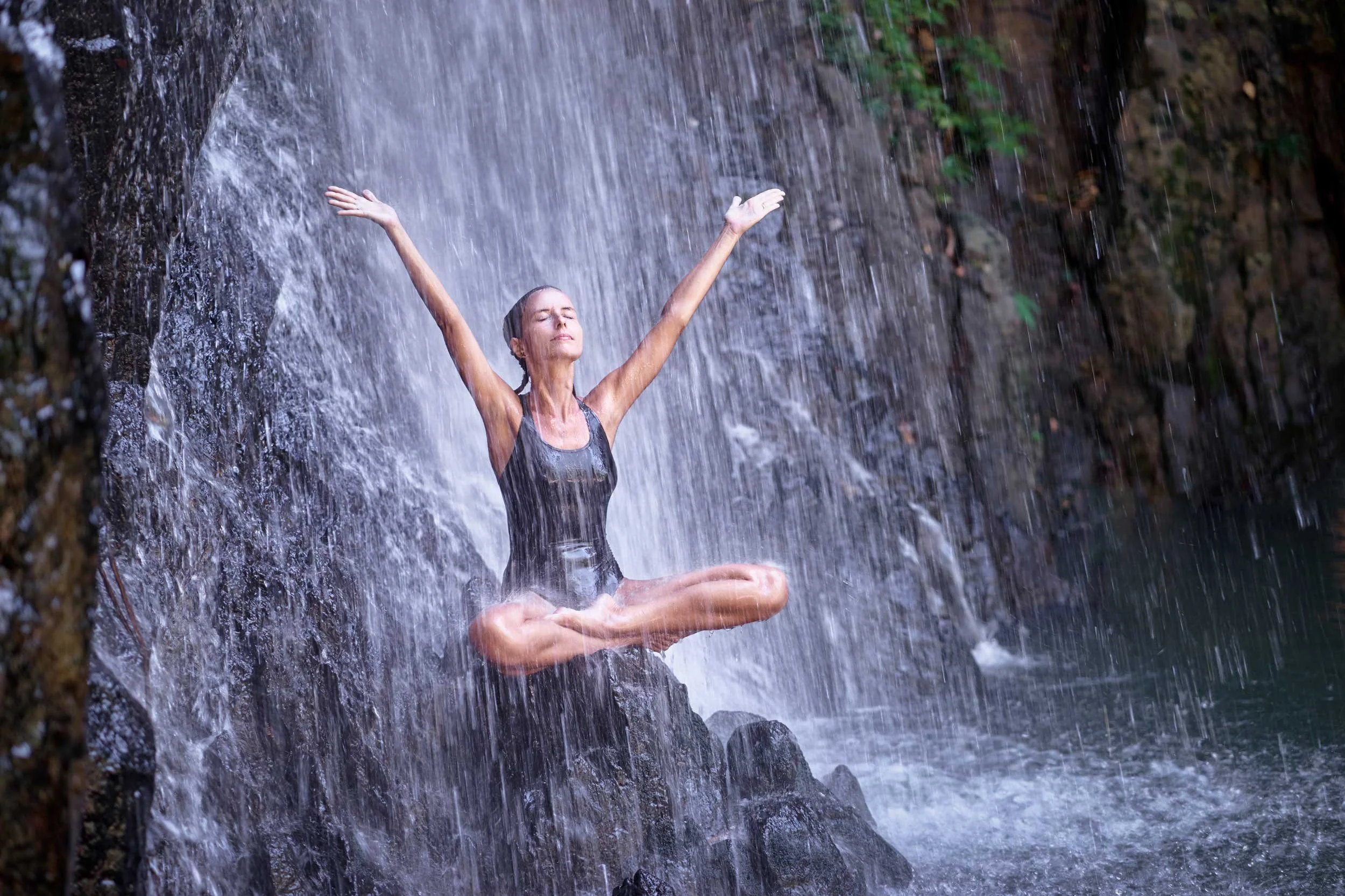 A woman under a waterfall.