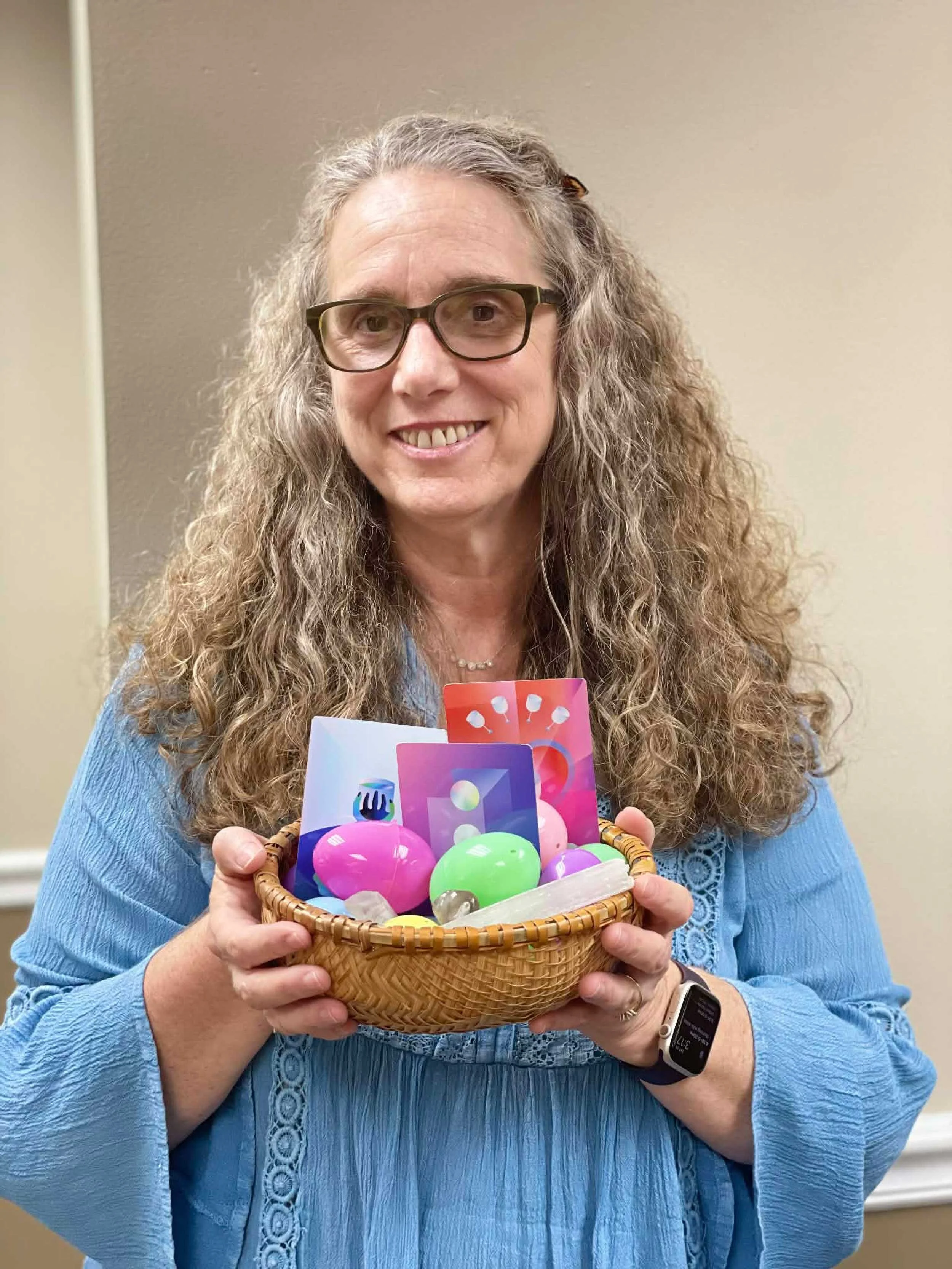 Christiana offering a basket of Easter eggs, tarot cards, and crystals.