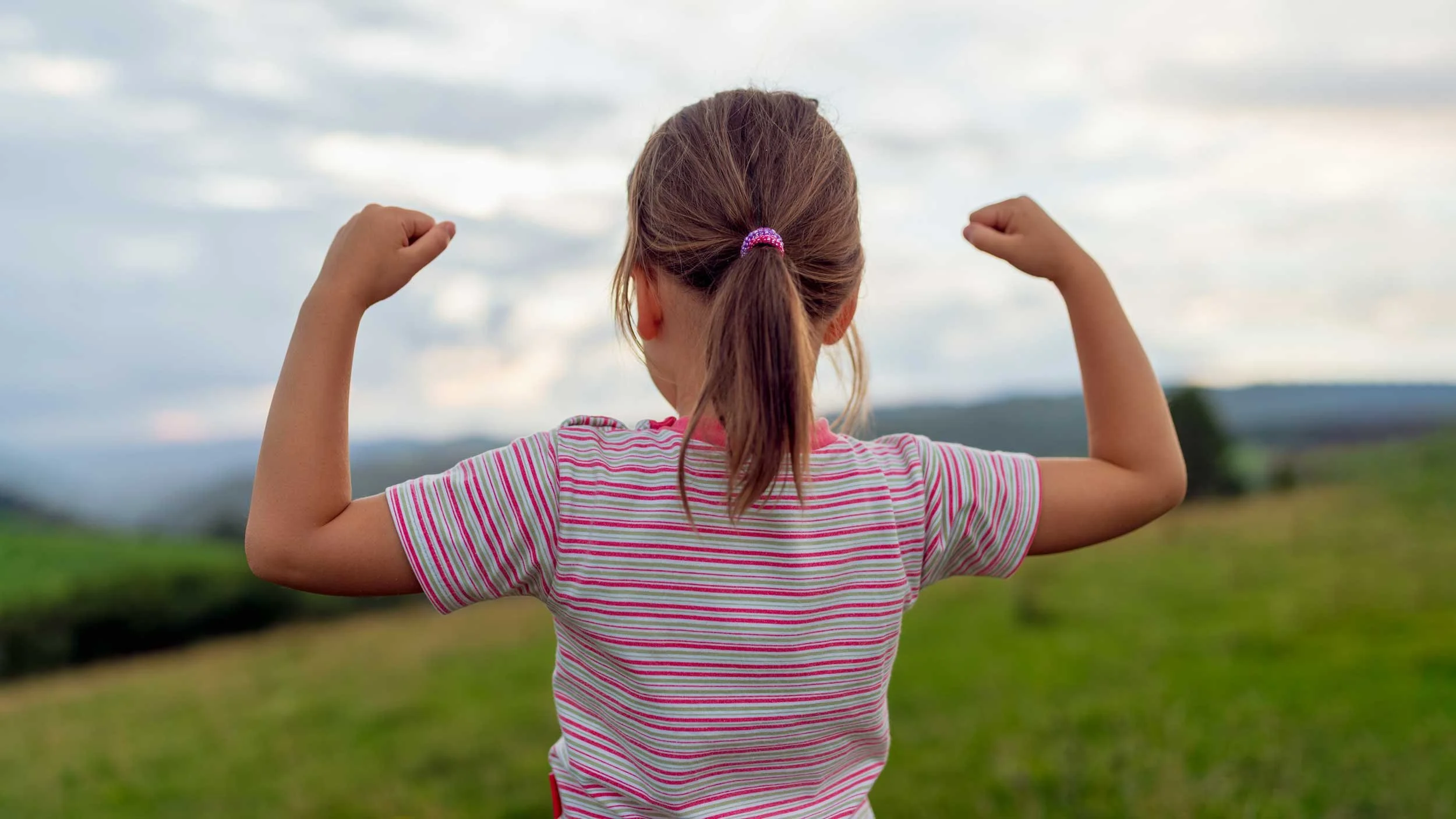 A young girl demonstrates her physical strength.