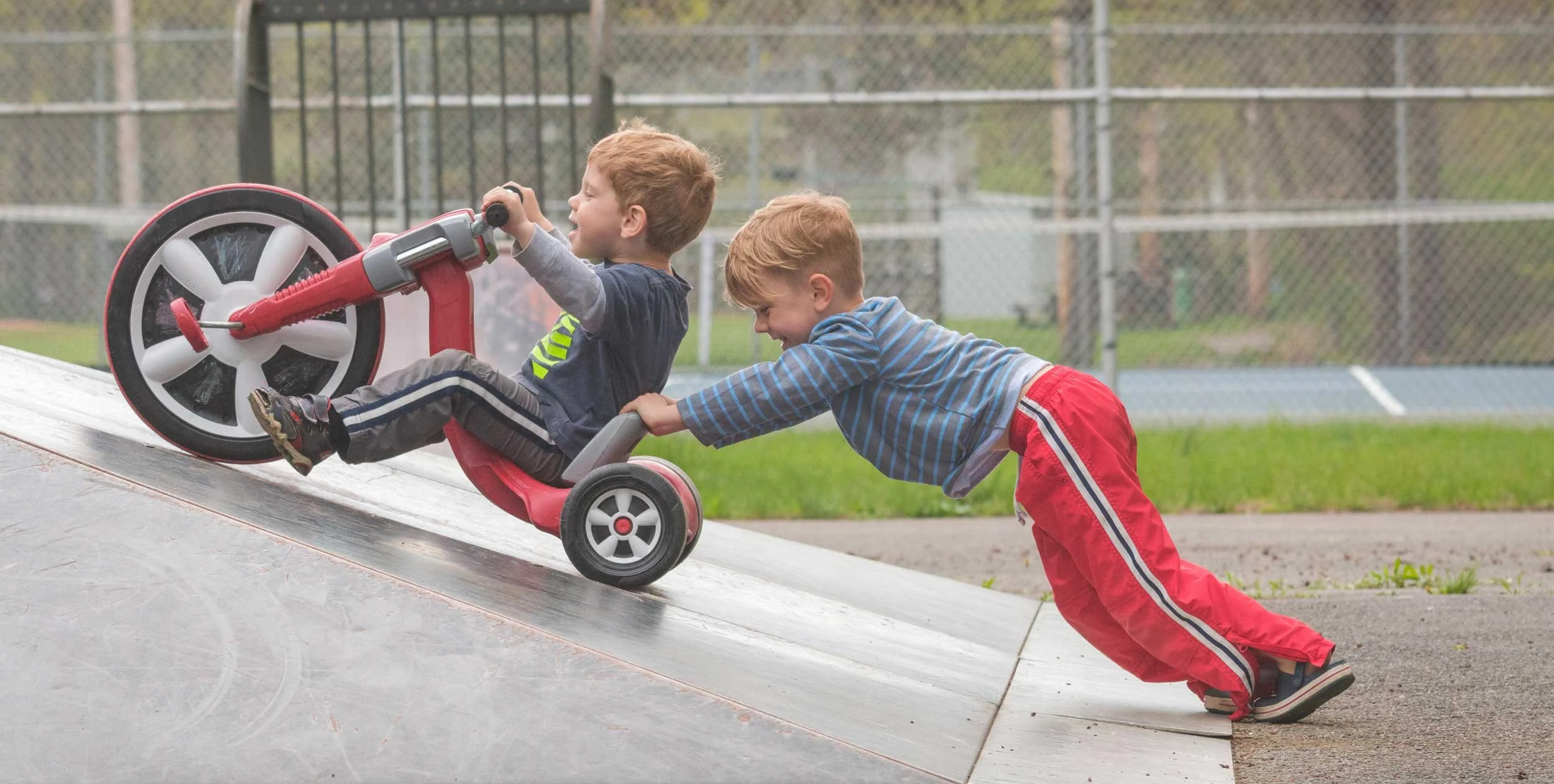 Photo of a child helping another child.