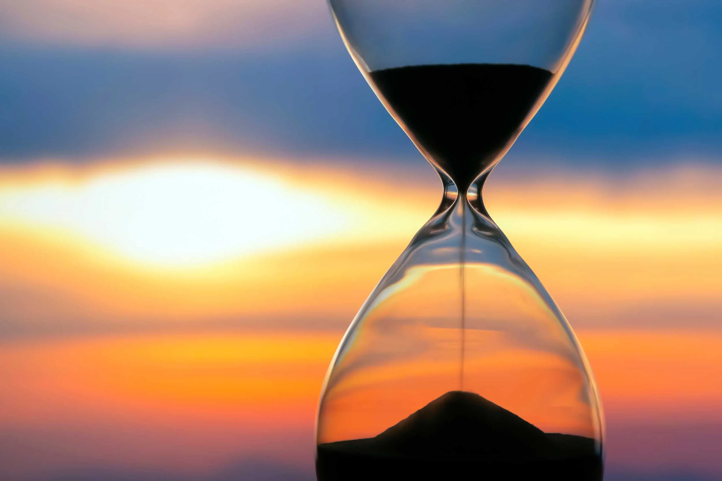 Hourglass on the background of a sunset.
