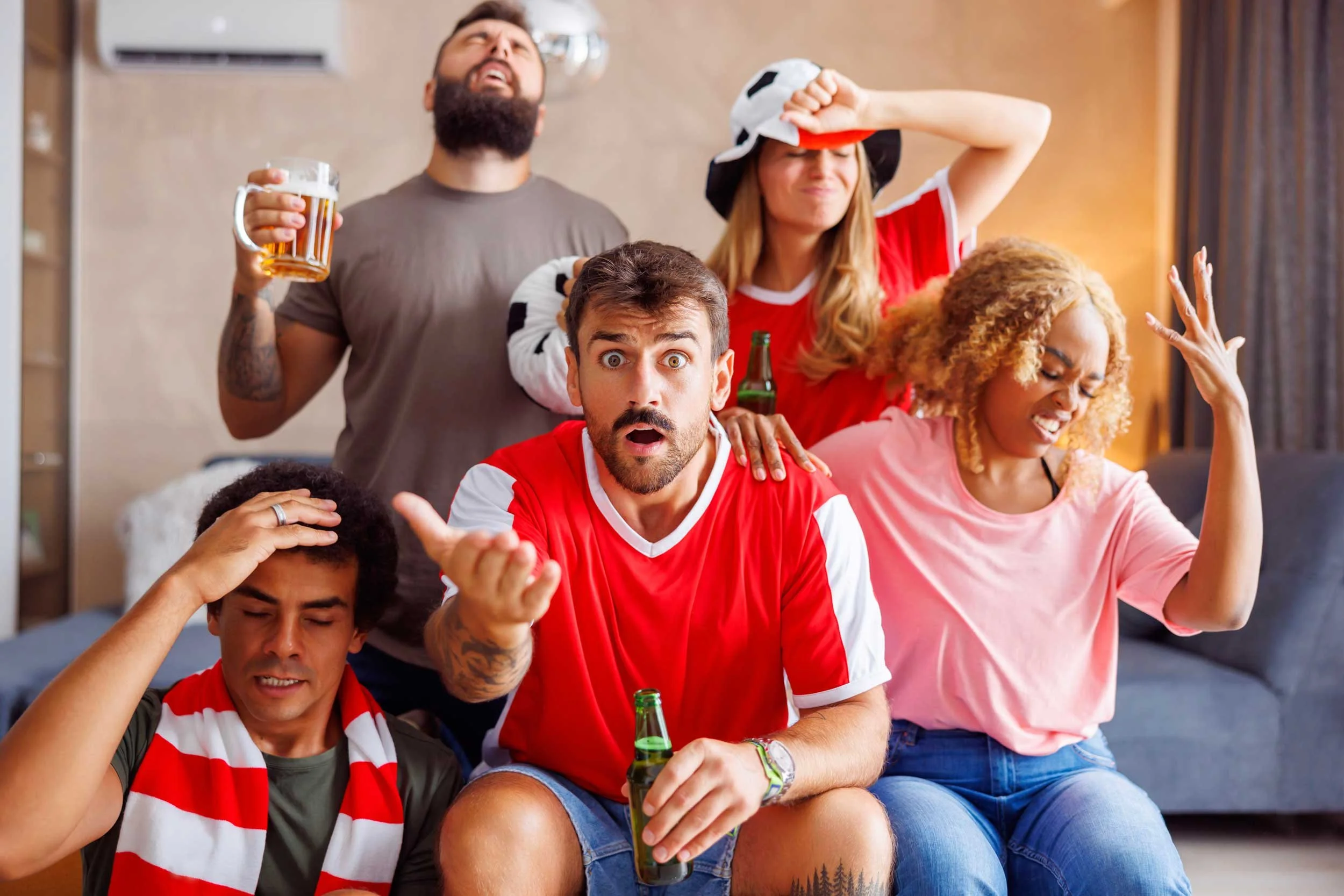 Sports fans watch a game on TV.