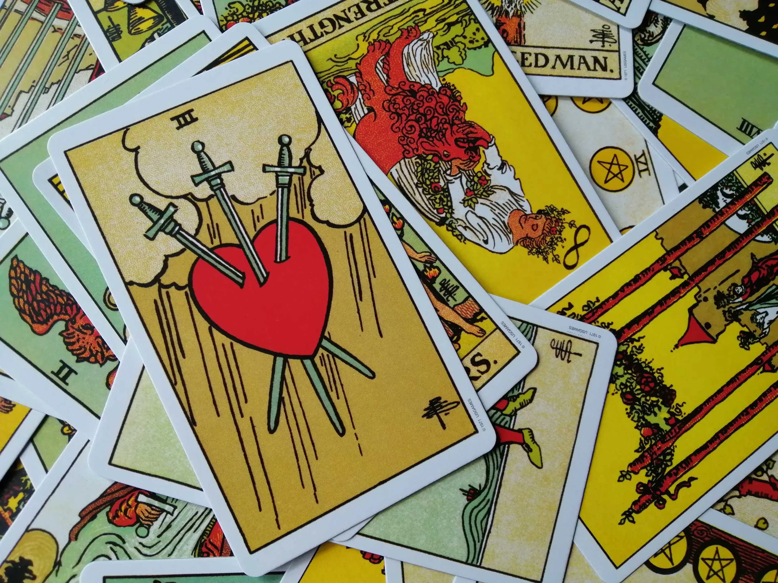 Tarot cards with a focus on the Three of Swords.