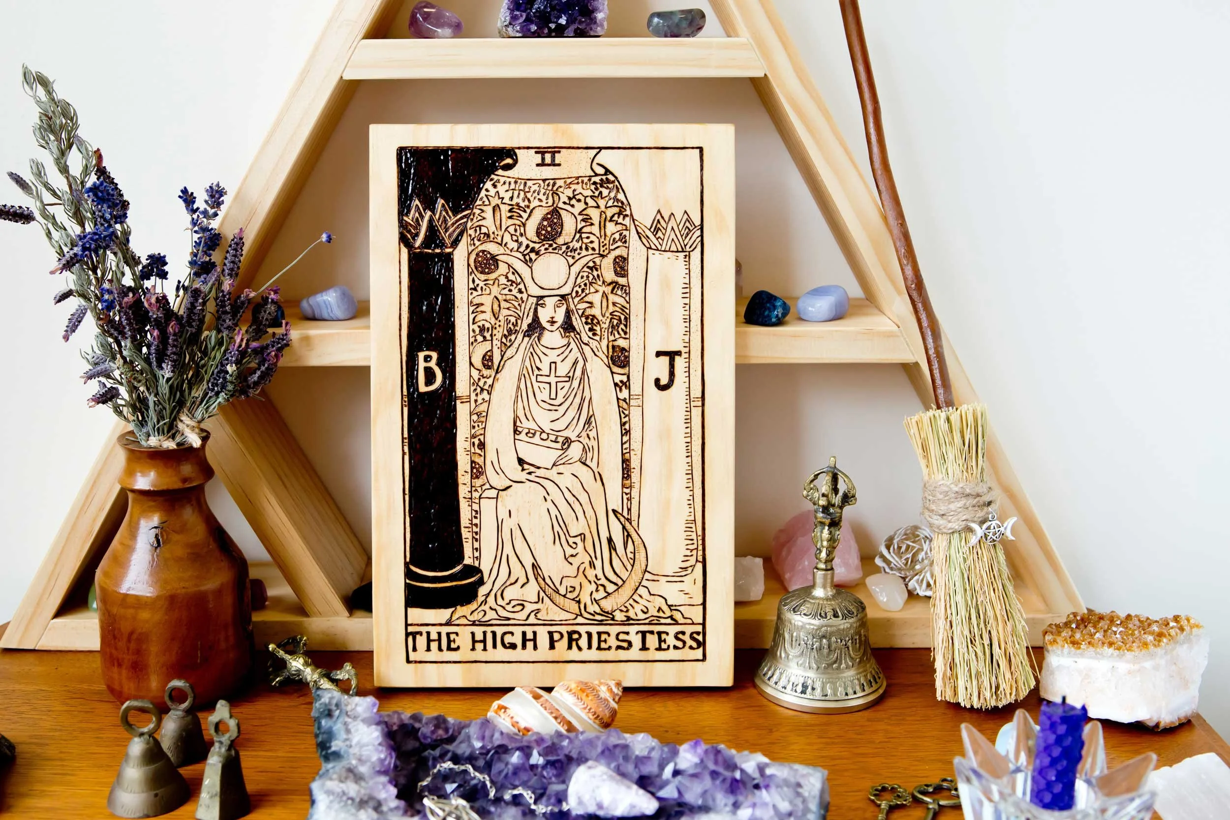 A wooden carving of the High Priestess on an altar.