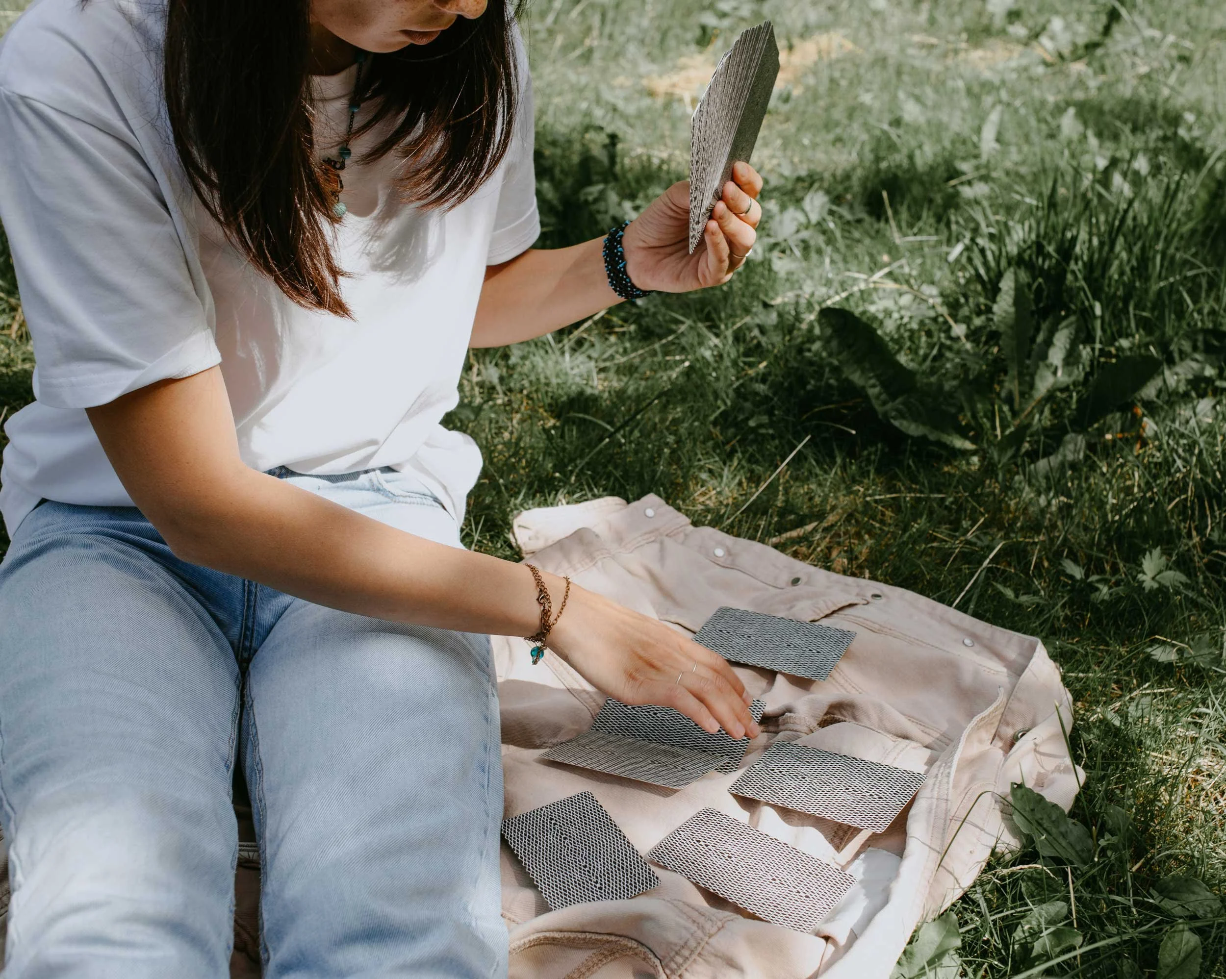 A woman reading tarot outdoors.