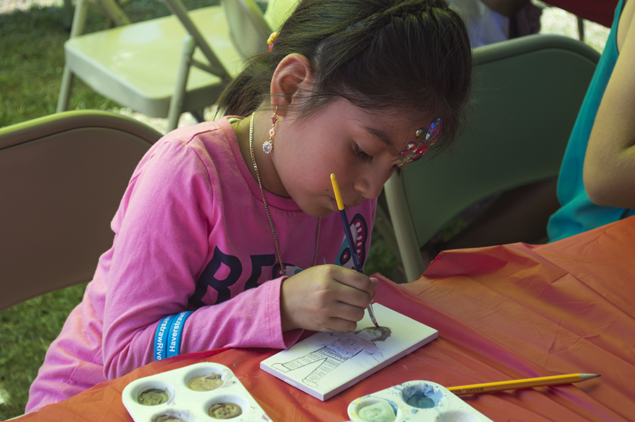 Child painting a tile in the Community Tile Project #3