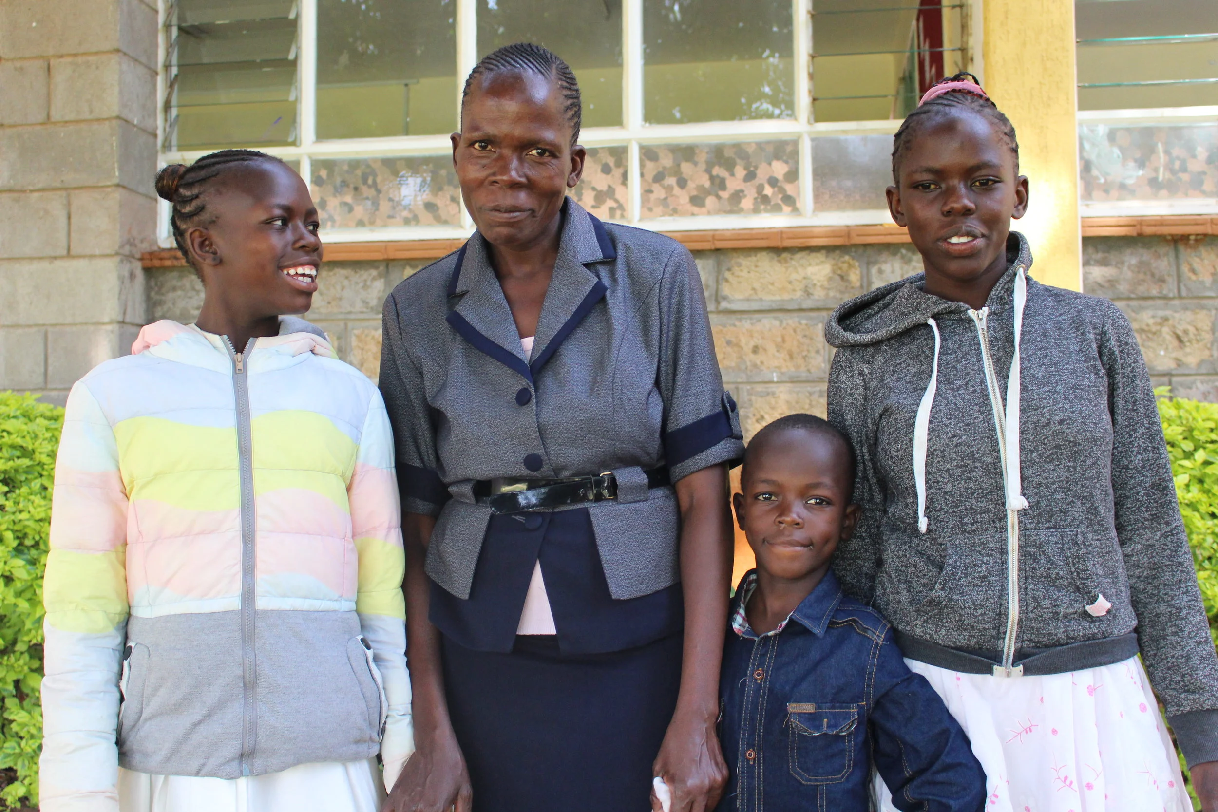 Mwajuma is surrounded by her children: Linah (the girl on the left), Evans (the small boy) and Jesminah (on the right).