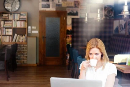 Blond woman with notebook in cafe drinking coffee