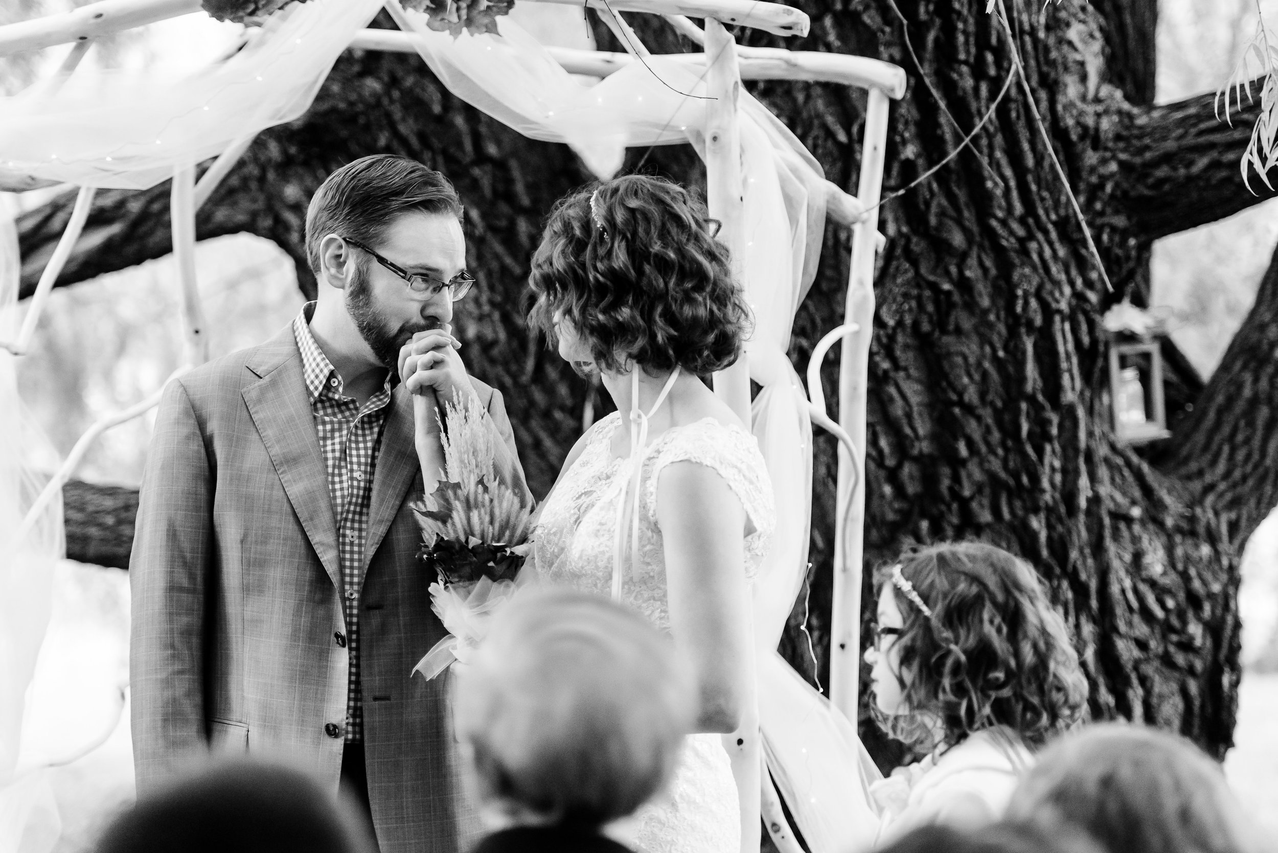 MN Landscape Arboretum - Chaska MN Wedding Photographer - Weeping Willow Trees Ceremony Site - Groom kisses bride hand