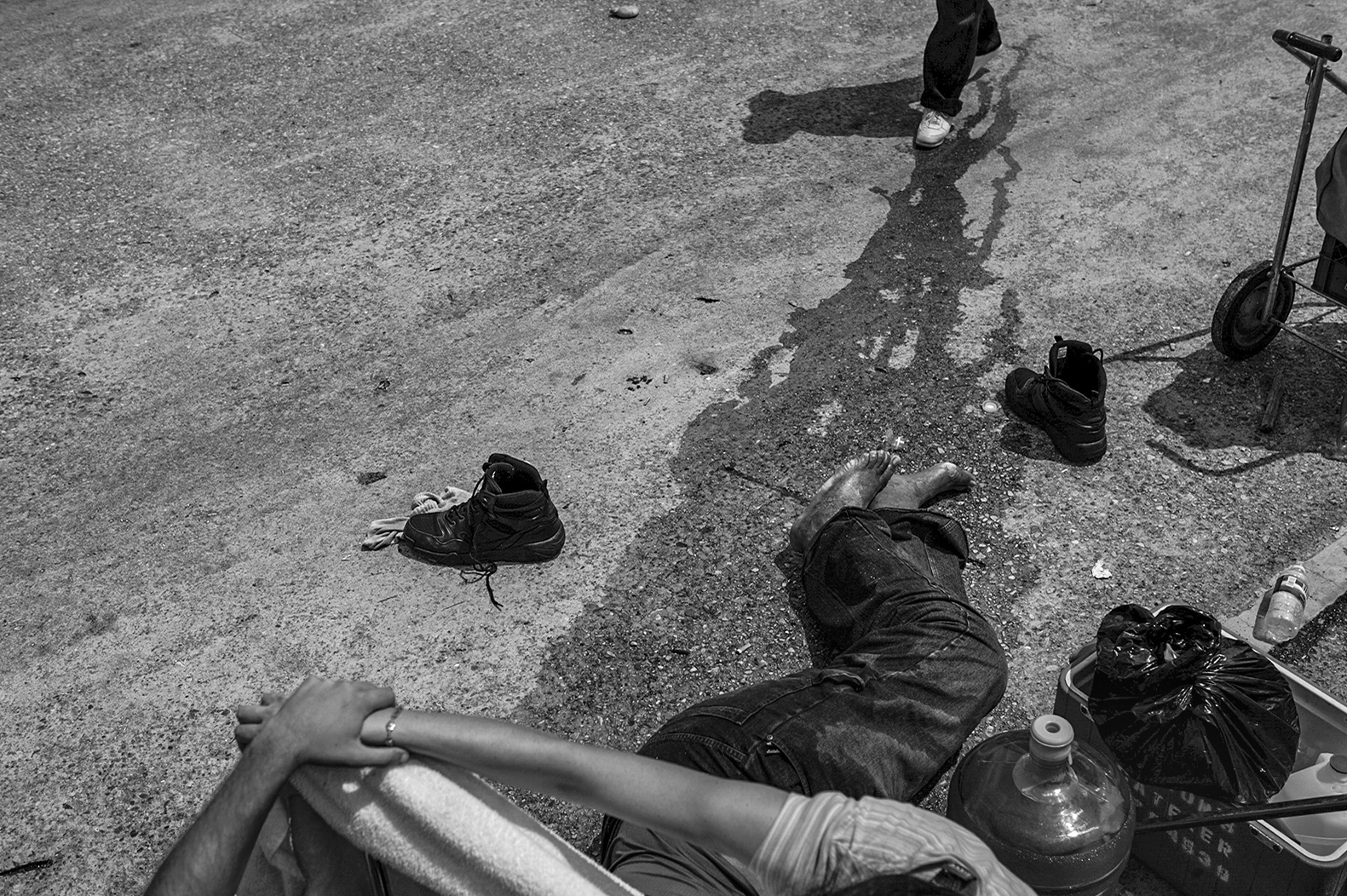 Helpless New Orleans residents stranded on interstate 10 provide shade for a man having a heart attack. 
