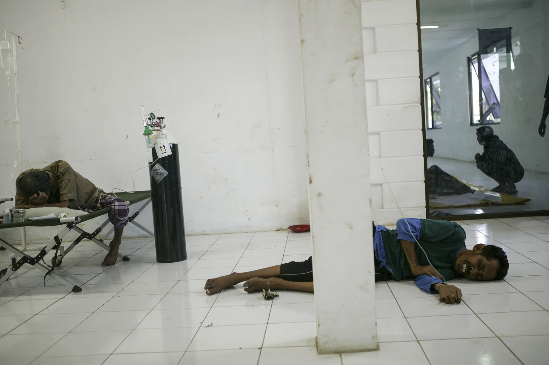 Injured survivors wait for medical attention at the emergency room of a hospital in Banda Aceh.