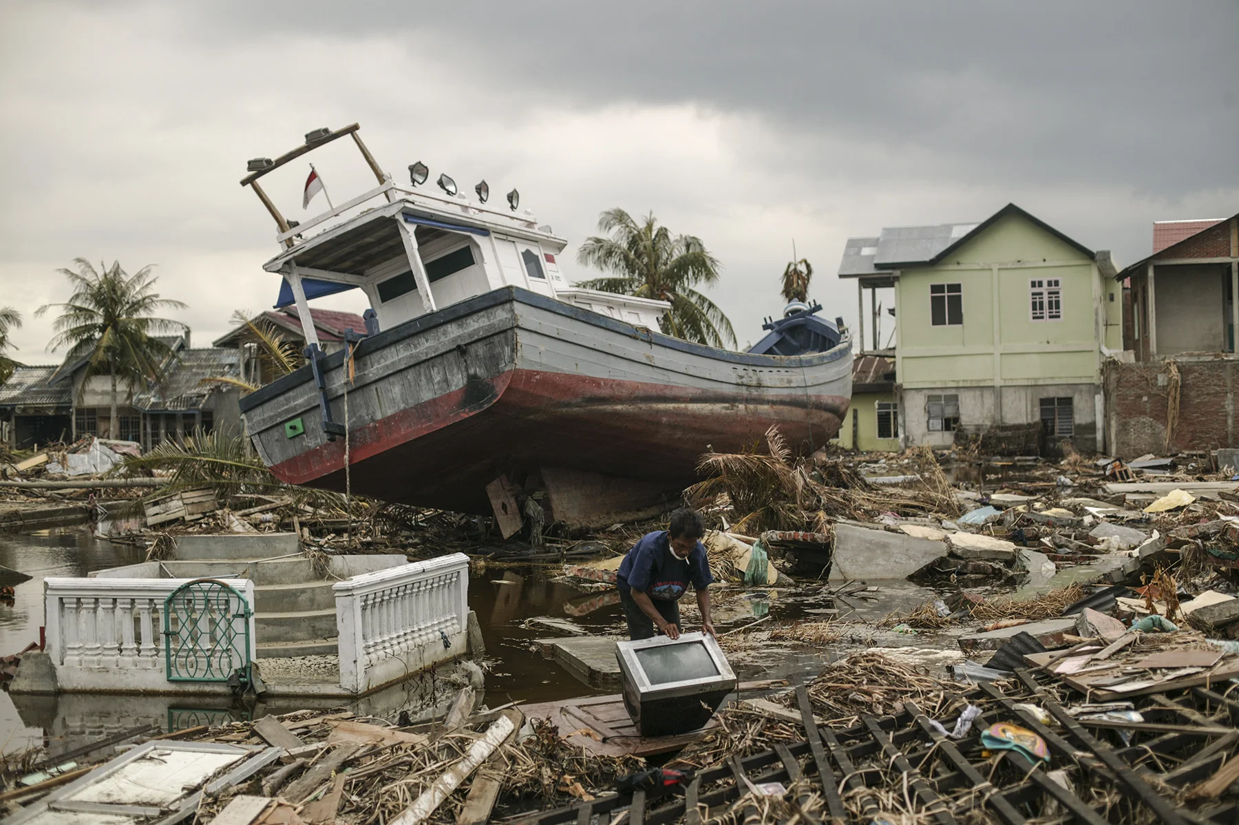 A man near what used to be his home salvaging what he can.