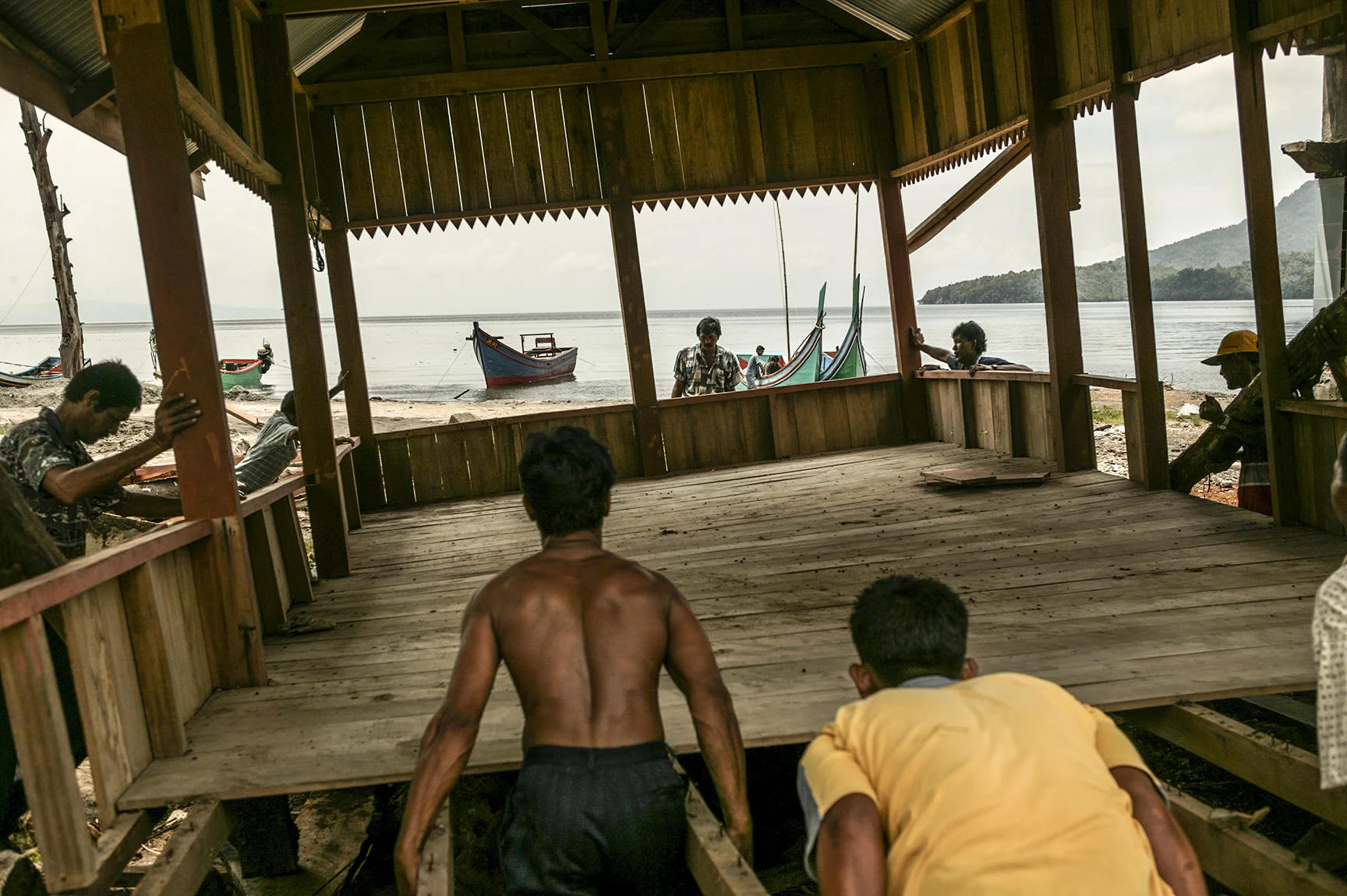 Locals of a fishing community work together to rebuild their homes.