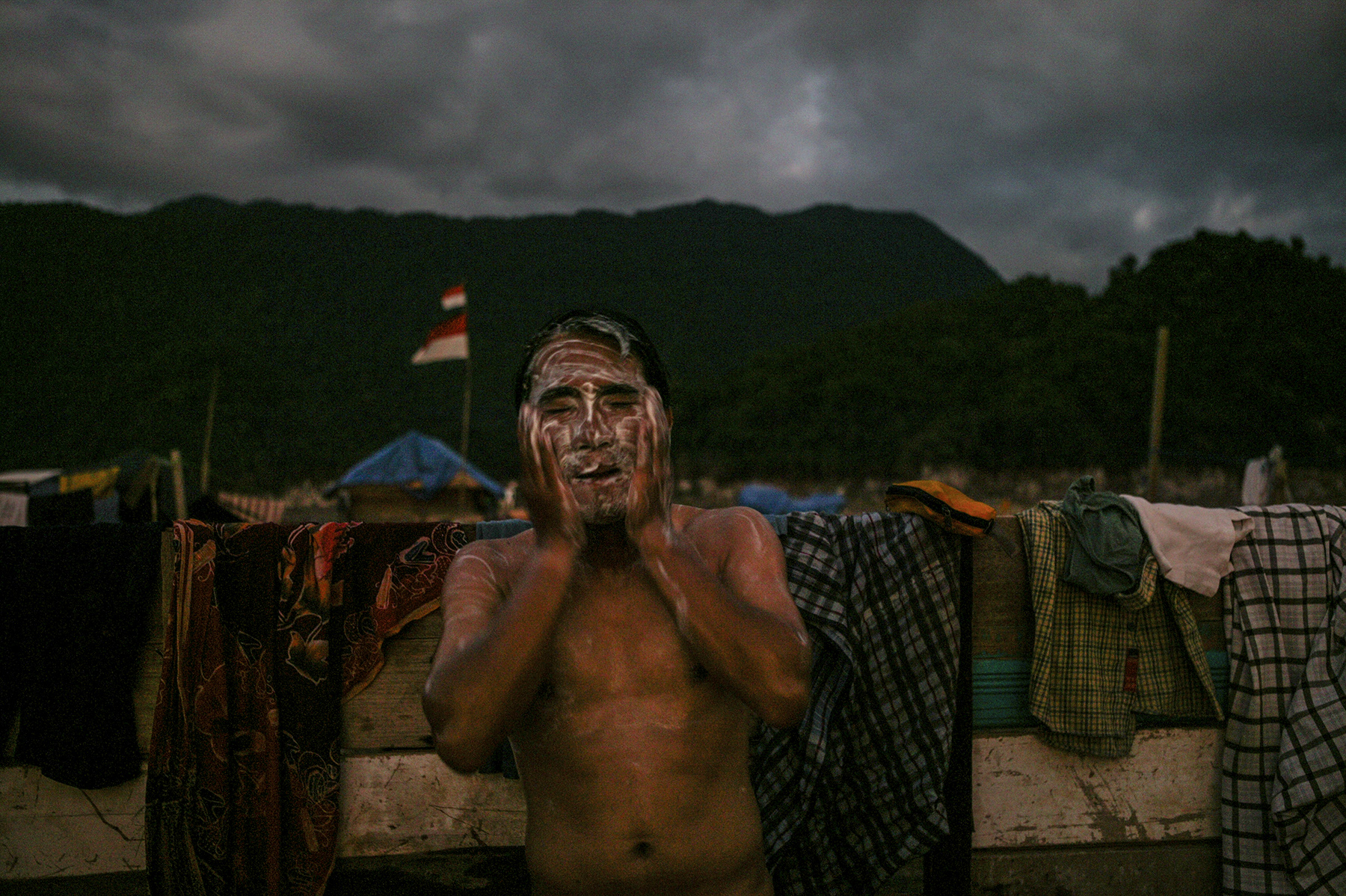 A man washes at dusk - at a camp for survivors. 