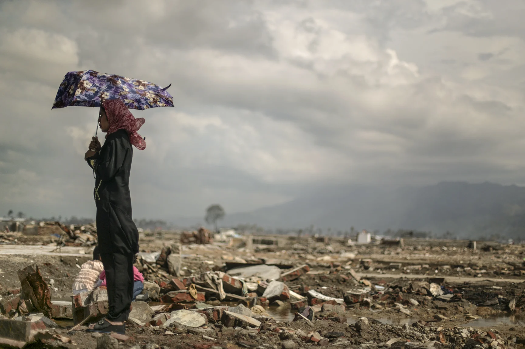 On the 100th day following the December tsunami, a woman returns to where her brother's home once stood.
