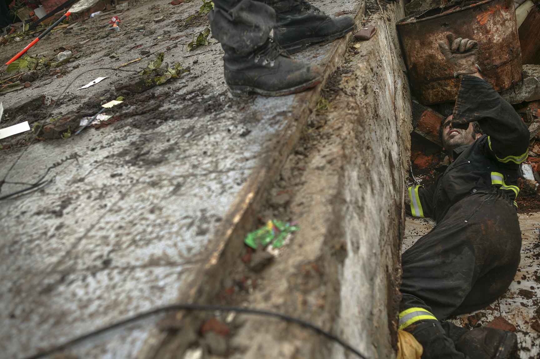 A Spanish search and rescue team searches a collapsed building for survivors. 