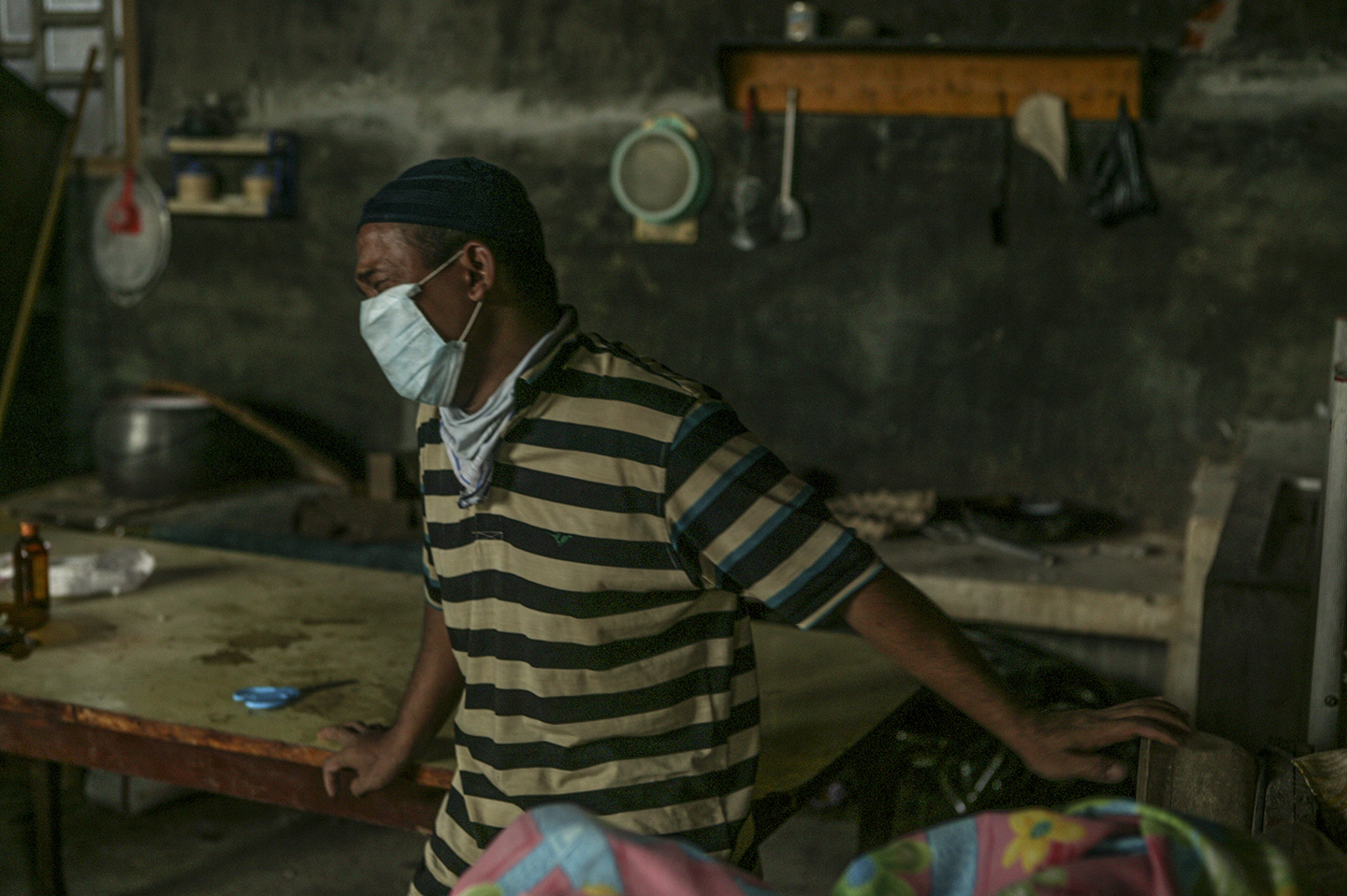  A man watches as a deceased family member is extracted from the rubble of a home. 