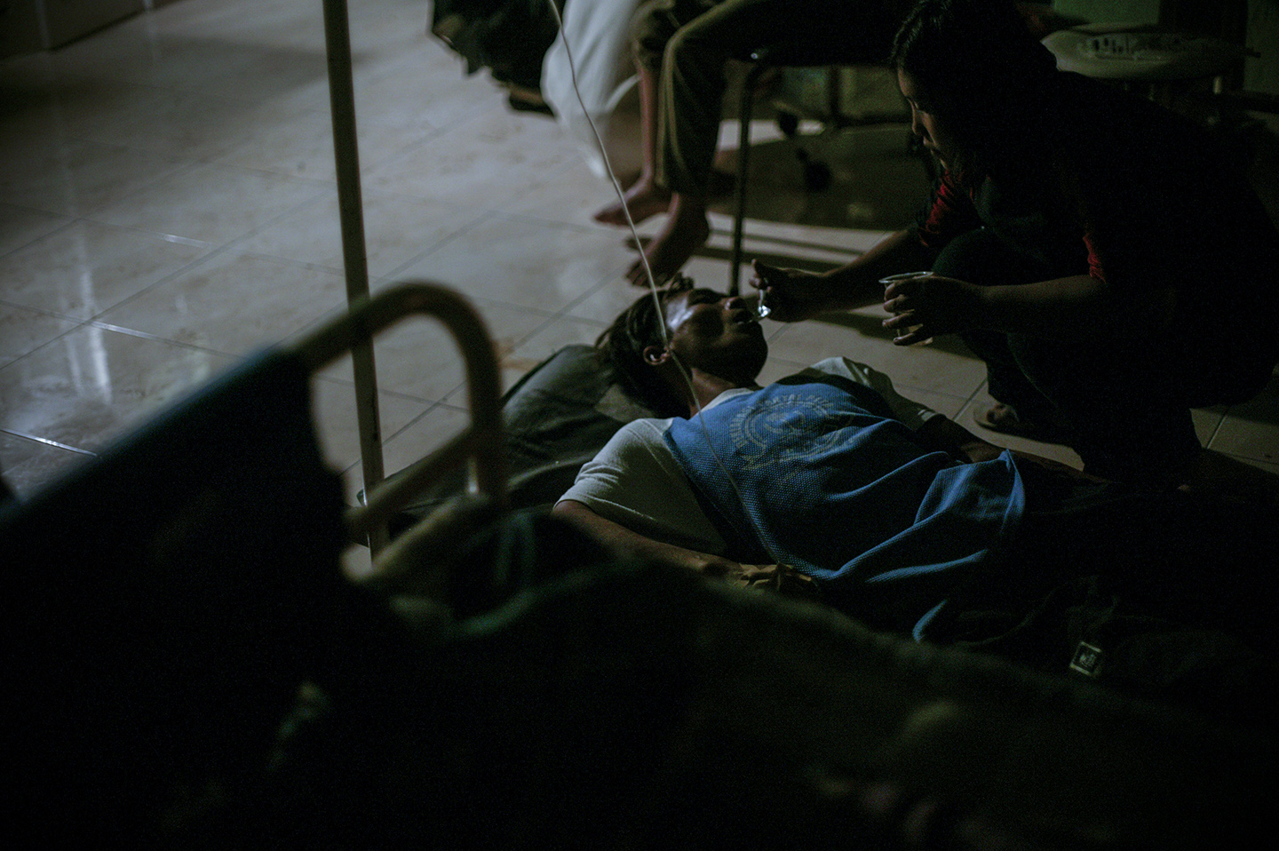 An injured man being fed by a family member at the hospital. 