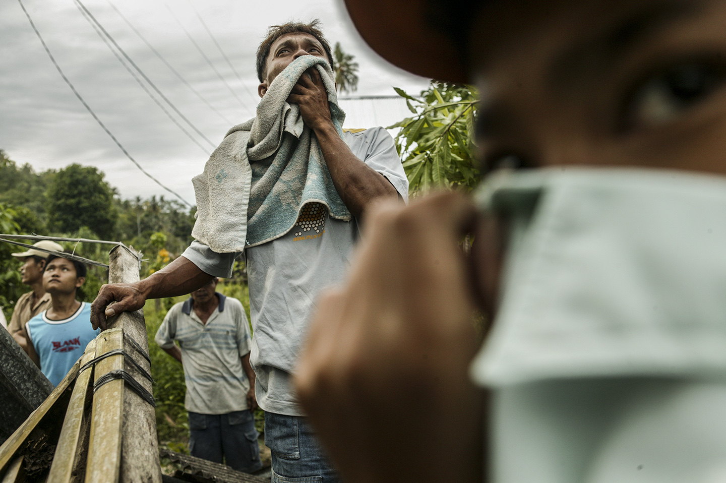 Locals watch as injured survivors are airlifted by helicopters.