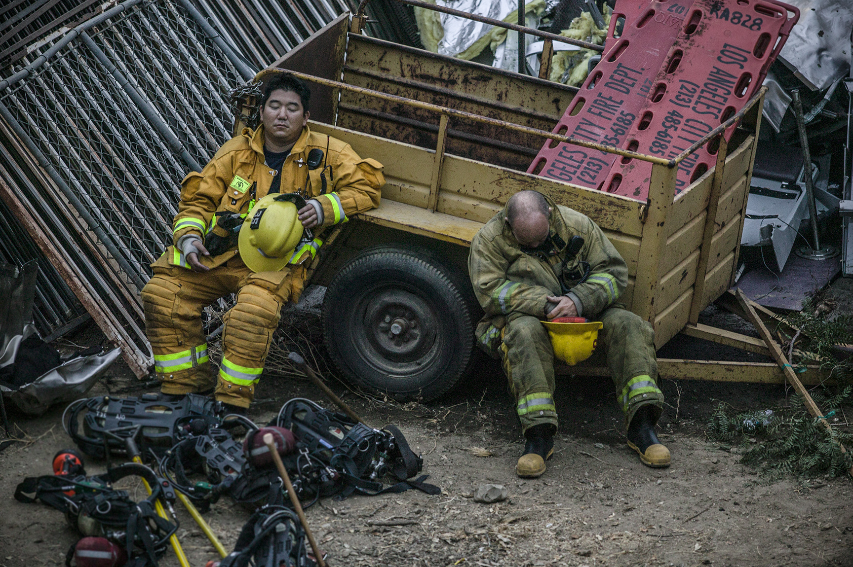 Exhausted firefighters find a moment of rest at the scene of a deadly train crash where 25 people lost their lives. 