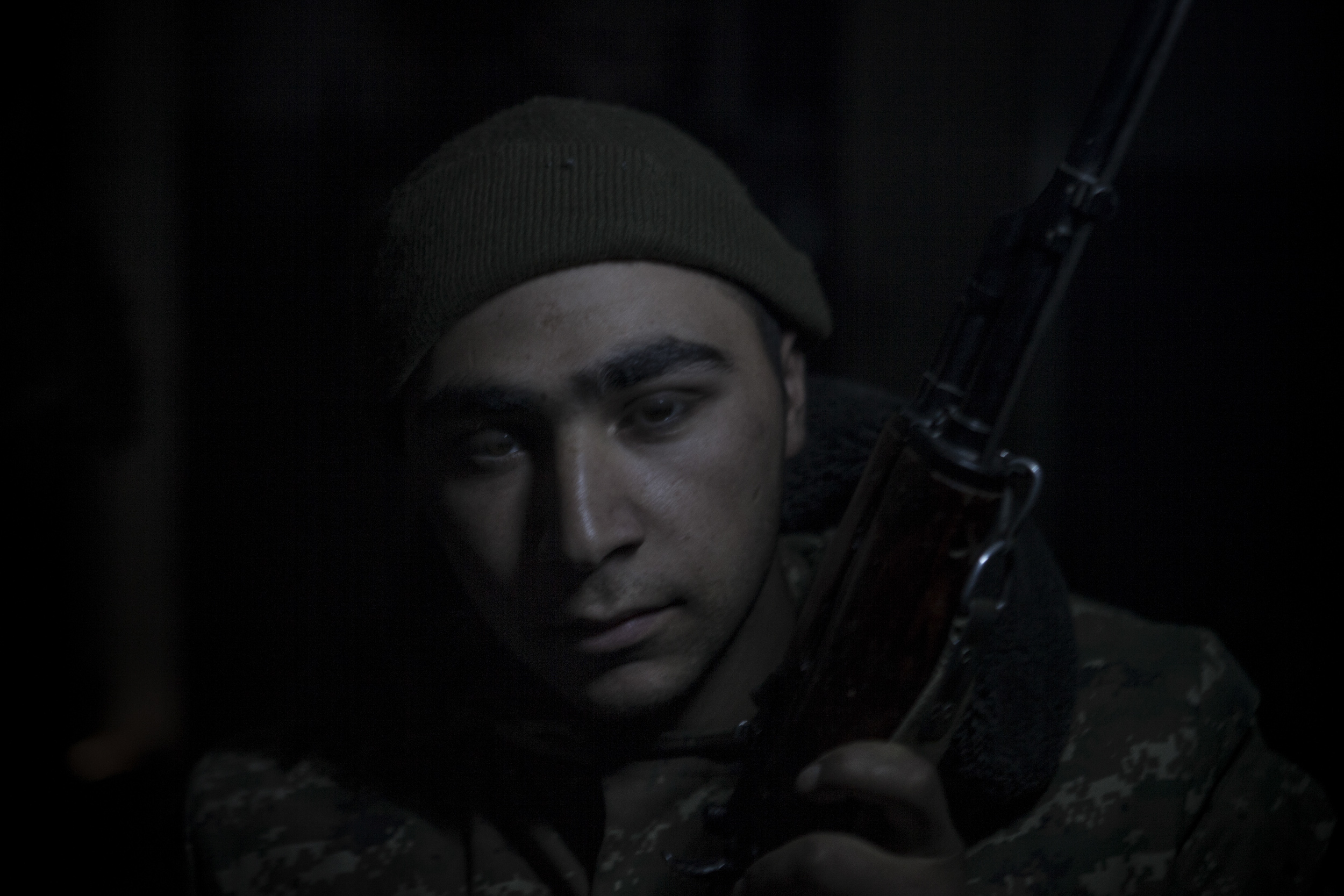 Soldiers awaiting orders in darkness, lit only by kerosene lanterns, at a military base in Mataghis, Karabakh on April 5.