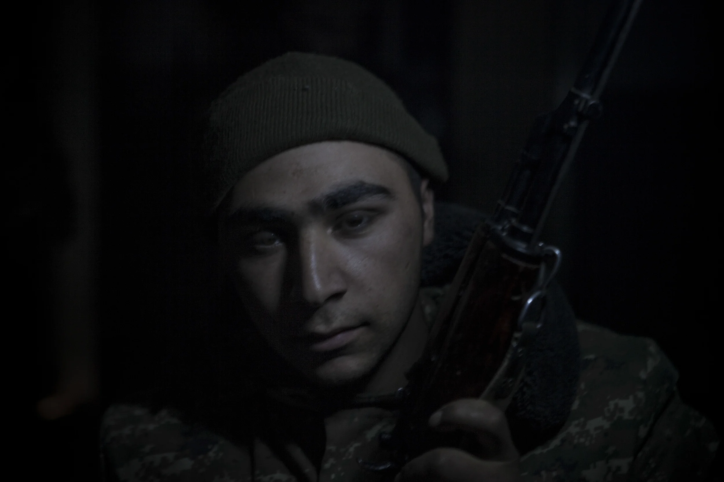 Soldiers awaiting orders in darkness, lit only by kerosene lanterns, at a military base in Mataghis, Karabakh on April 5.
