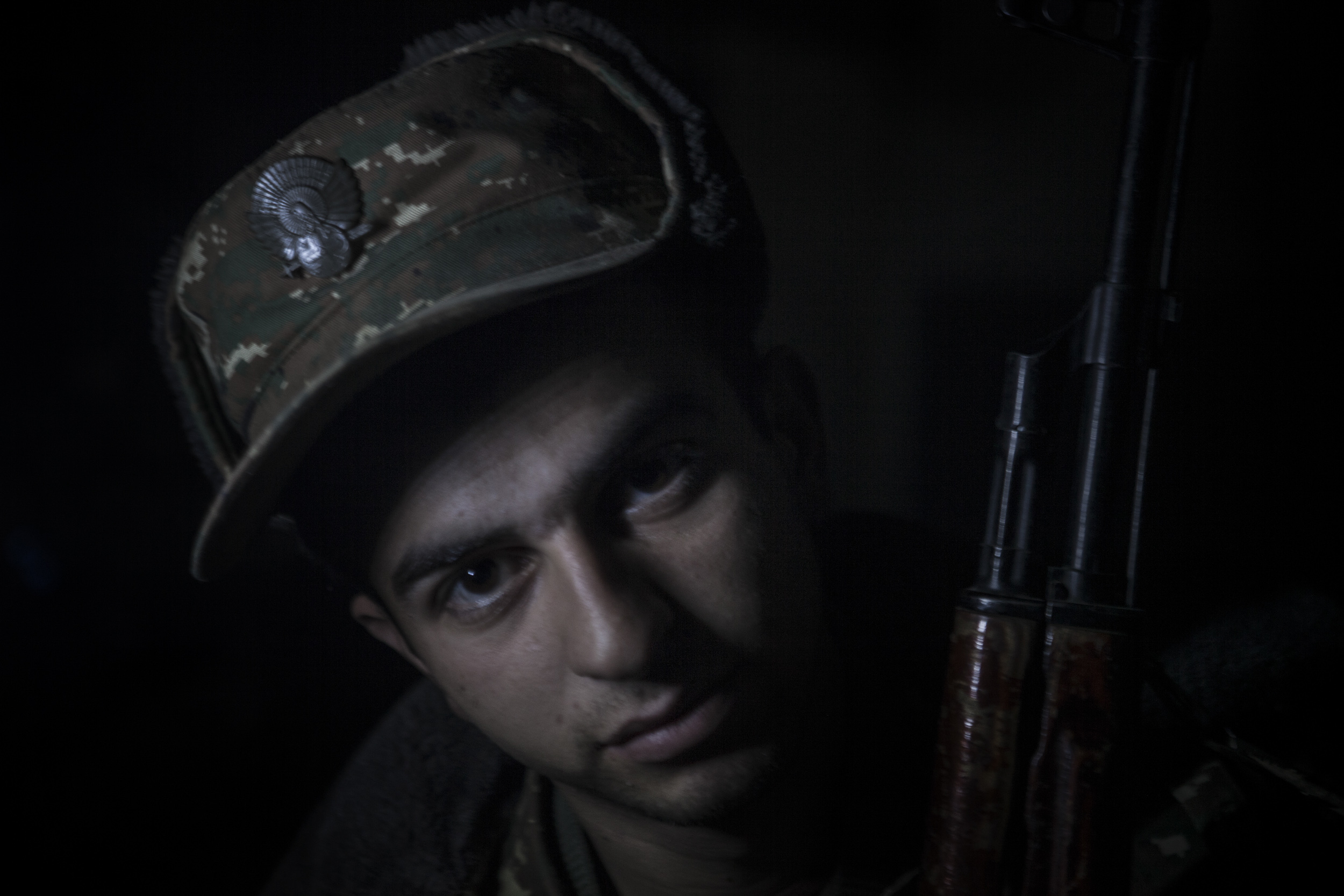 Soldiers awaiting orders in darkness, lit only by kerosene lanterns, at a military base in Mataghis, Karabakh on April 5.