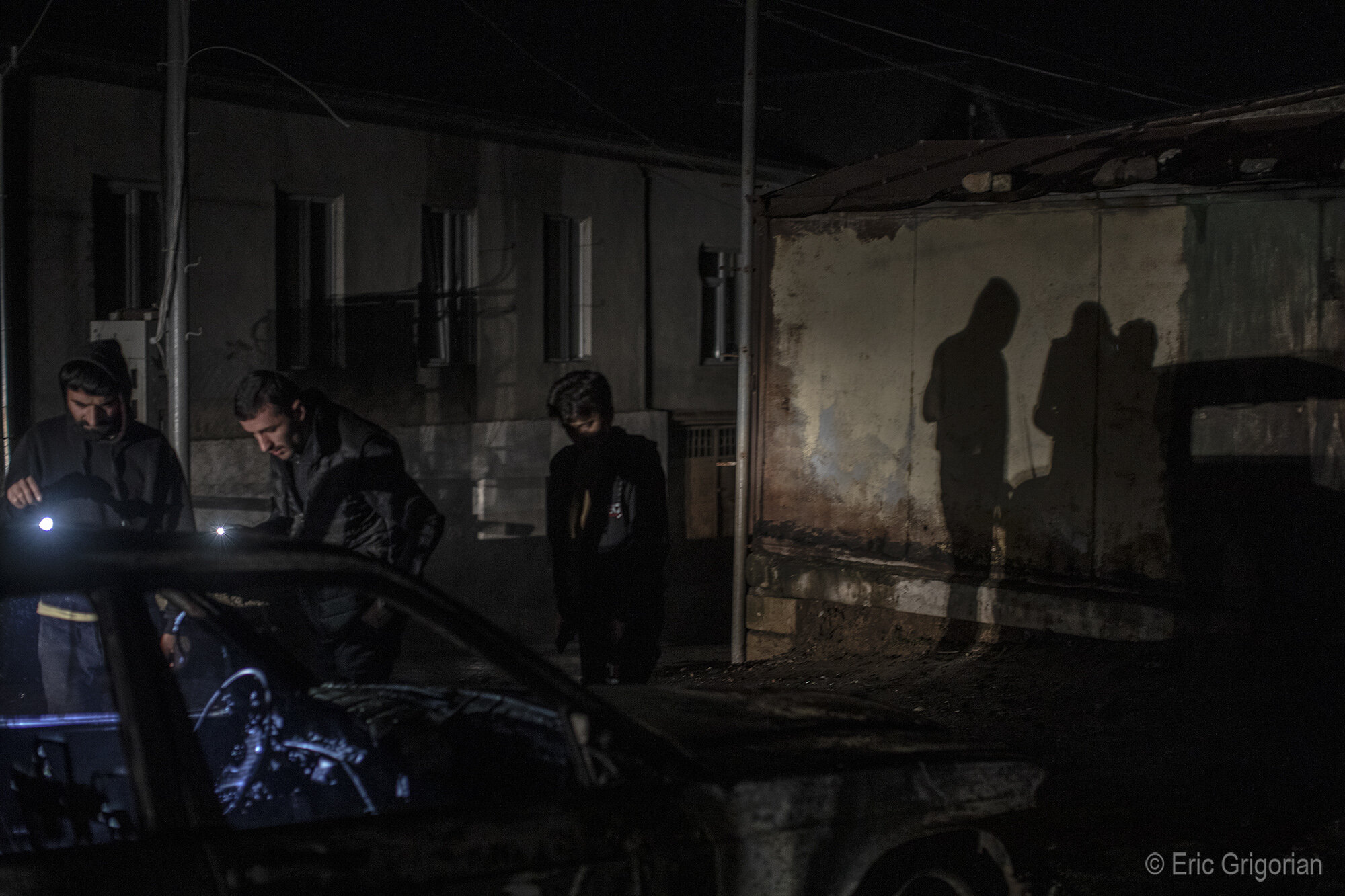  Residents examine a blown-out car after a shelling of the Stepanakert market on the evening of Oct. 3. 