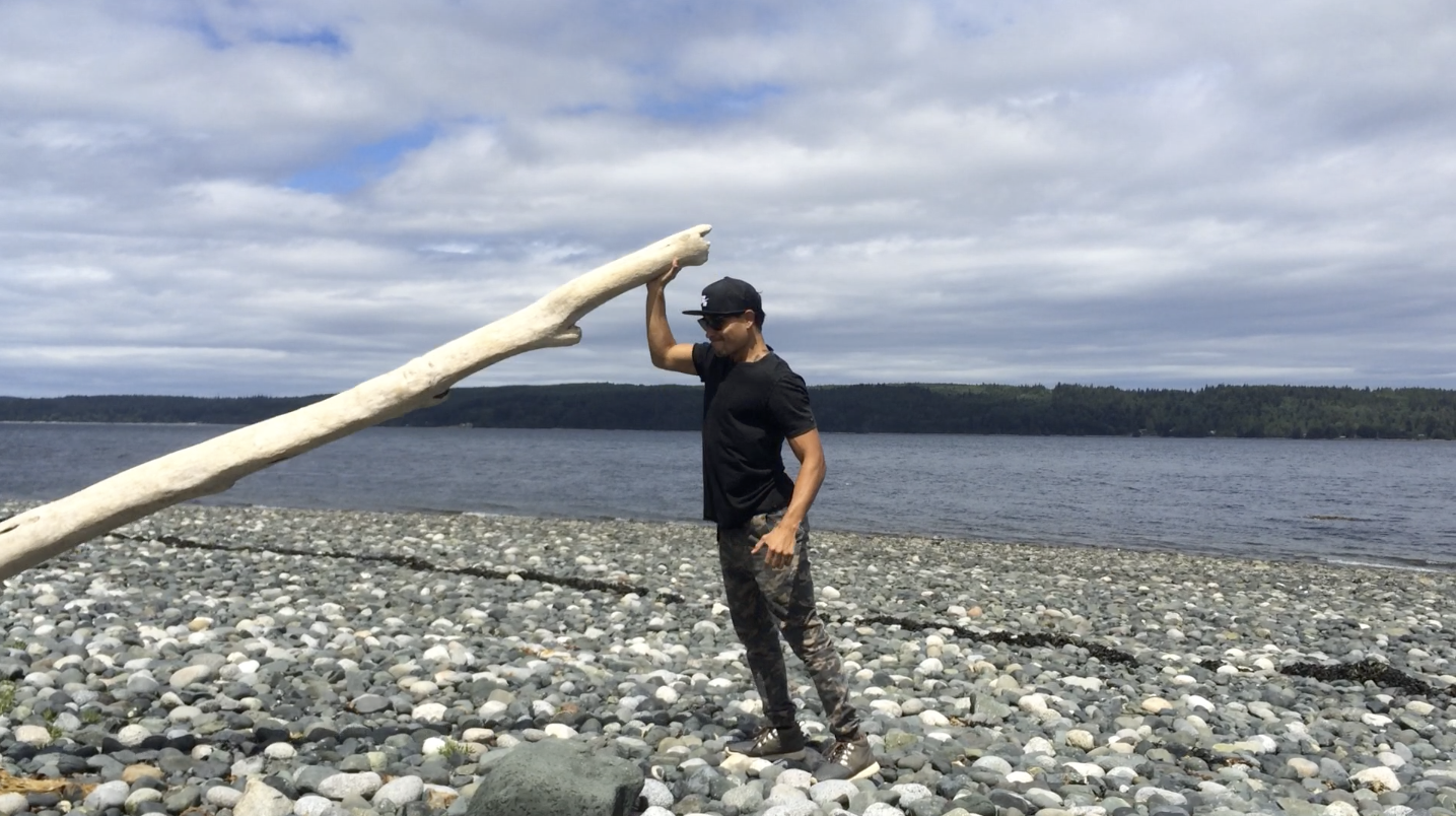 Thosh Collins using drift wood for weight resistance while visiting Alert Bay, BC, Canada.
