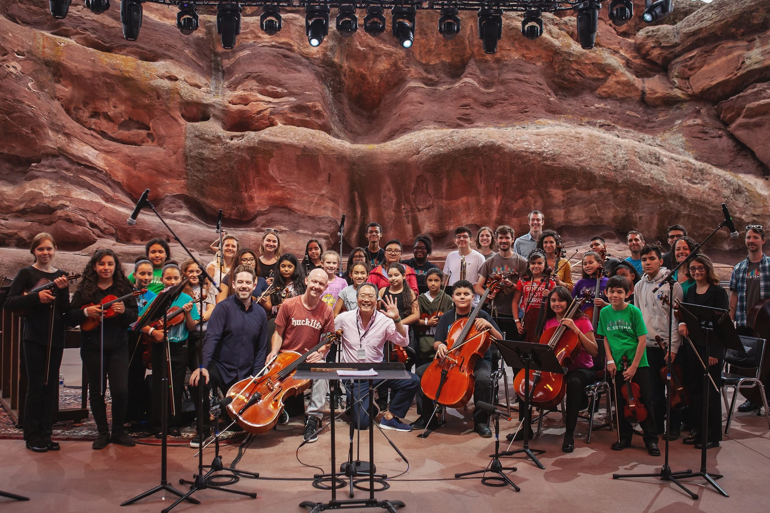 Brett Mitchell, Isaac Slade (lead singer of The Fray), Yo-Yo Ma, and El Sistema Colorado pose for a group photo after a rehearsal at Red Rocks Amphitheater in Morrison, CO. (Photo by Amanda Tipton)