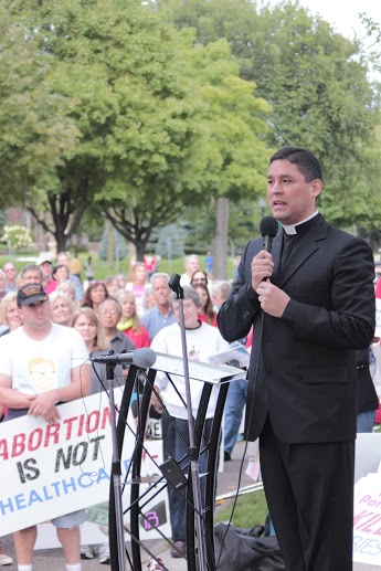 Fr. Humberto Palomino, St. Mark's Catholic Church "My eyes are drawn to this sign--'Planned Parenthood commits 9-11 every 3 days and then sells the victims.'"