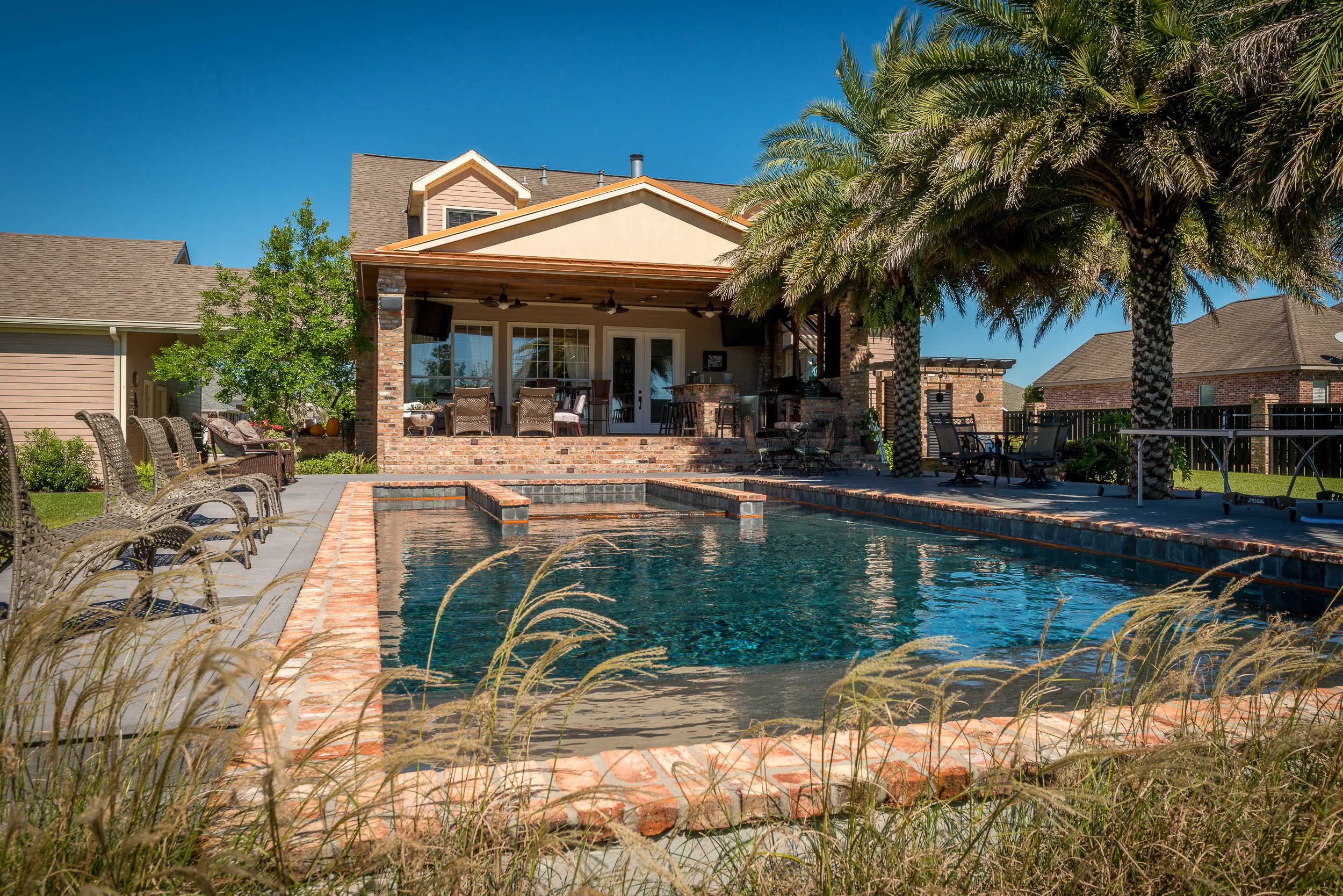 A pool, outdoor kitchen, and powerful sound system make this beautiful backyard a favorite gathering place for family and friends.