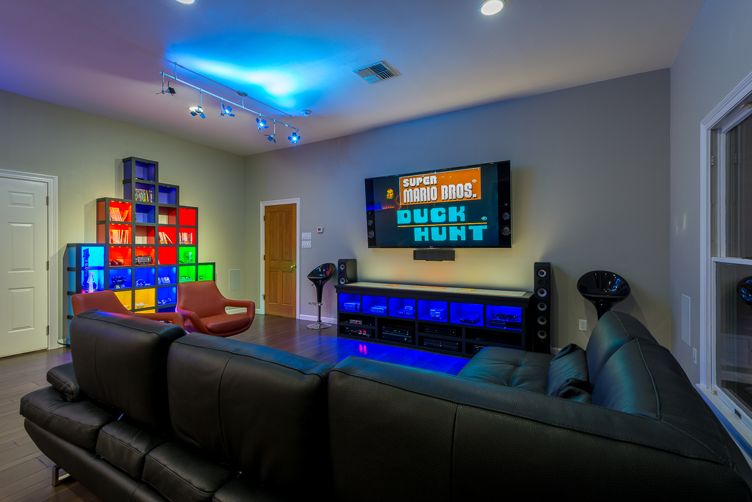 This family's arcade room features 6 generations of gaming devices, from NES to XBox One. The "Tetris Wall" storage shelf and custom media console were built by Josh Hebert at Marlin Construction of Houma, while DJ Chauvin of First Circuit provided all of the tech lighting.
