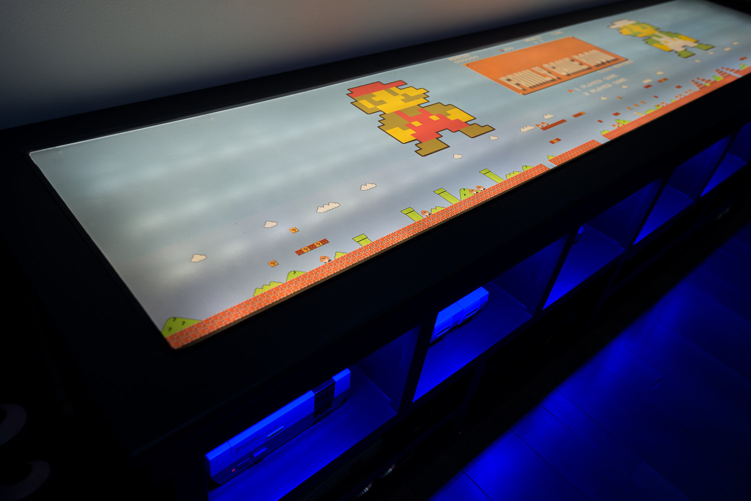 The top of the media console features a dual layer of buffed out plexiglass, diffusing the 60-plus underlying LED bulbs that illuminate the clear vinyl graphics on top.