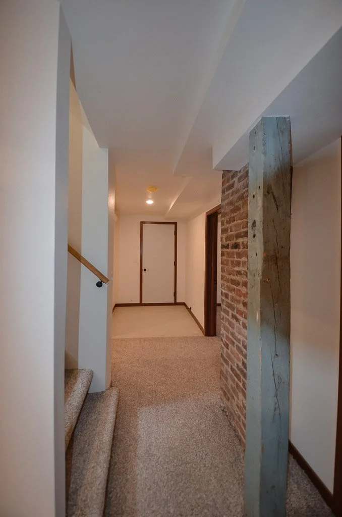 downstairs hall: laundry on left, bedroom on right, garage at end