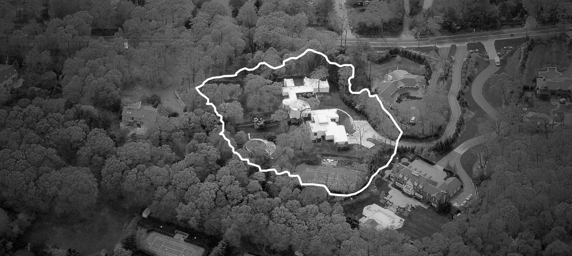 Site Context: The property is nestled by mature trees and the grade falls dramatically away from the house.